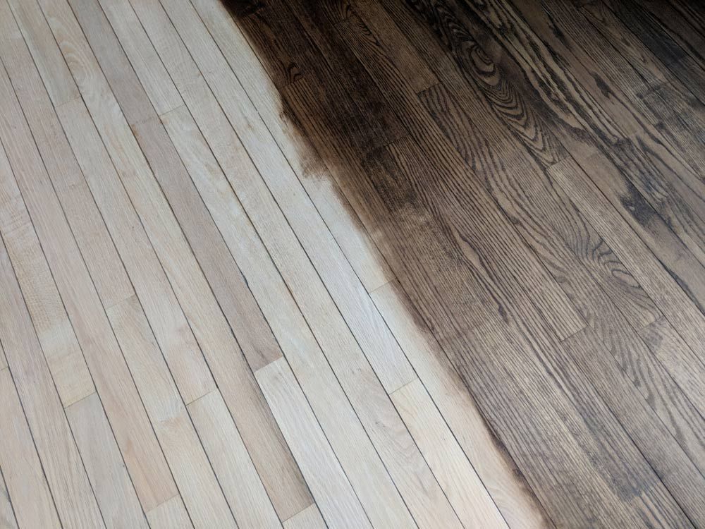 A Wooden Floor is Being Painted Half White and Half Black — Coastline Floor Sanding in Wyong, NSW