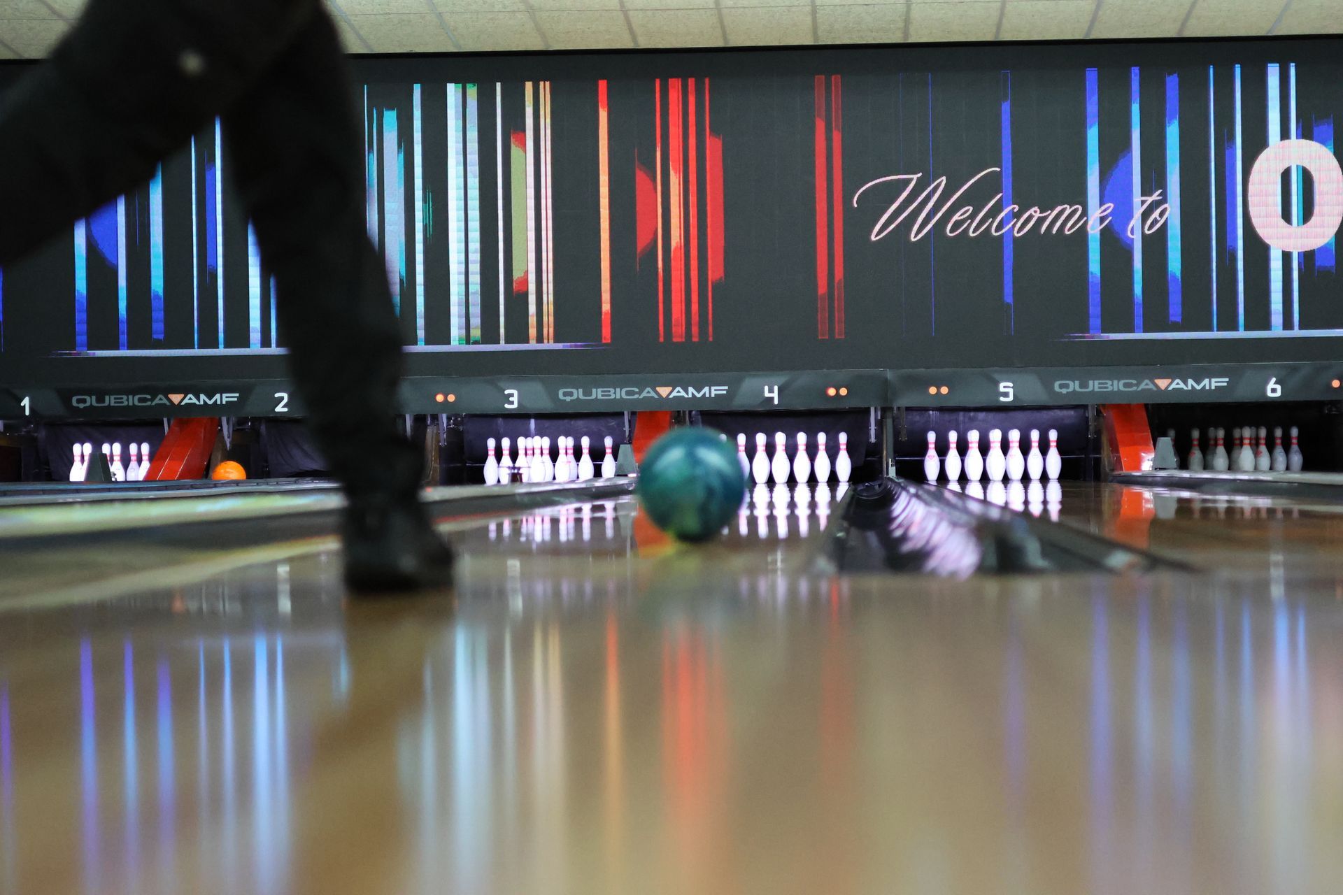 Bowling Lane With a Teal Ball Rolling Toward the Pins and a Bowler’s Legs — Orange Tenpin Bowl in Orange, NSW