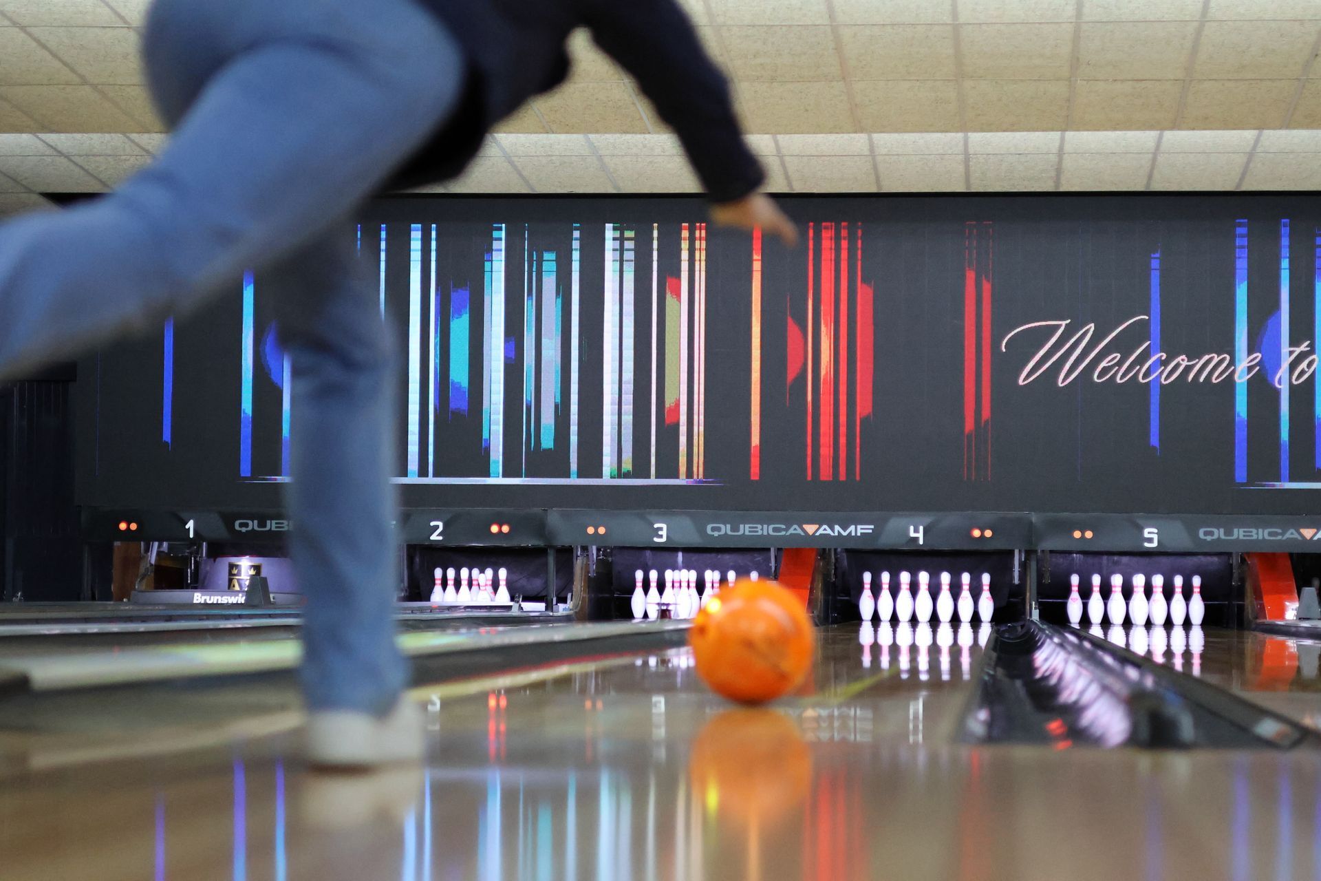 Bowler Releasing Orange Ball Down a Lit Bowling Lane Toward Pins at a Neon-lit Alley — Orange Tenpin Bowl in Orange, NSW
