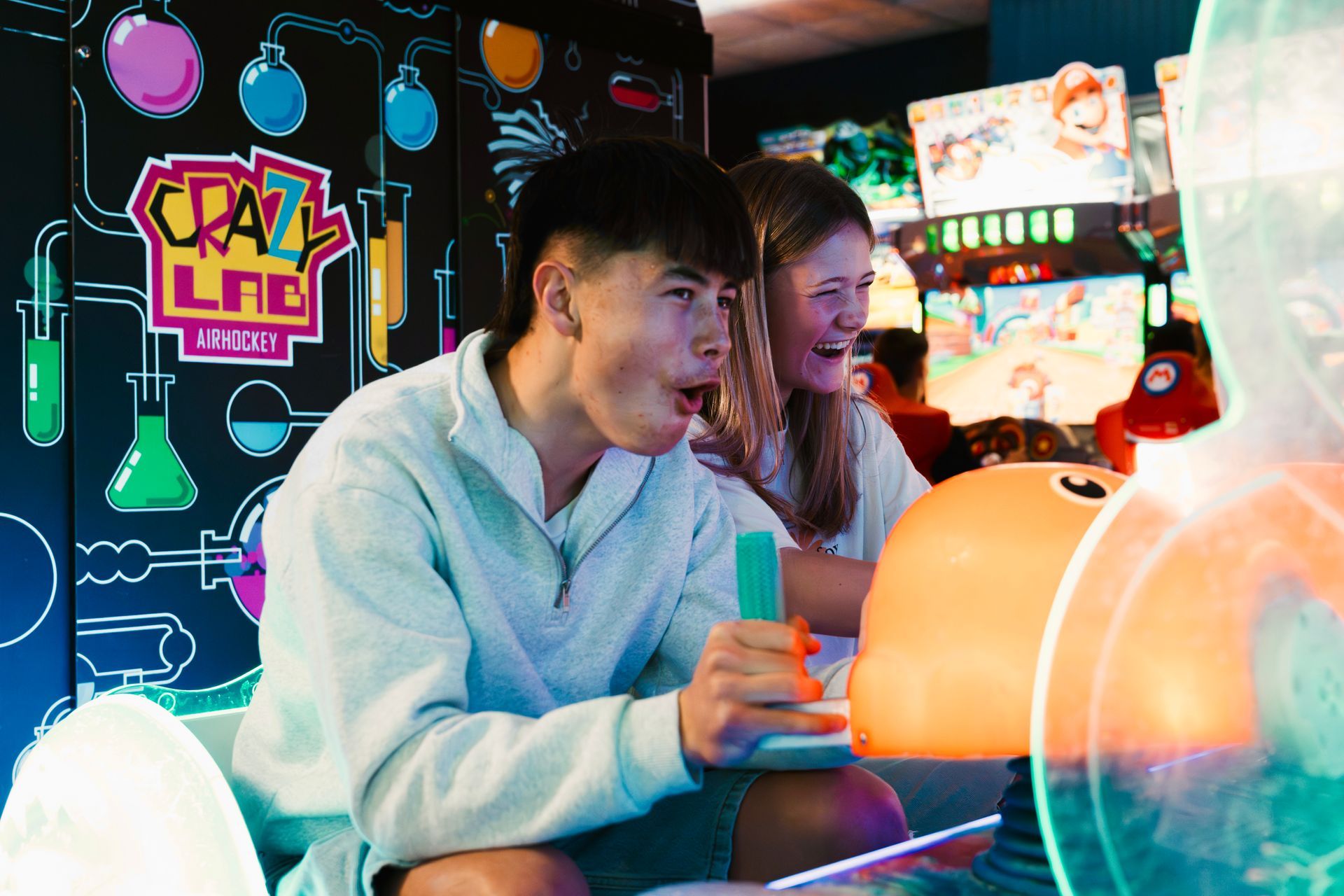 Two People Playing Arcade Games, Smiling at a Neon-lit Arcade Machine — Orange Tenpin Bowl in Orange, NSW