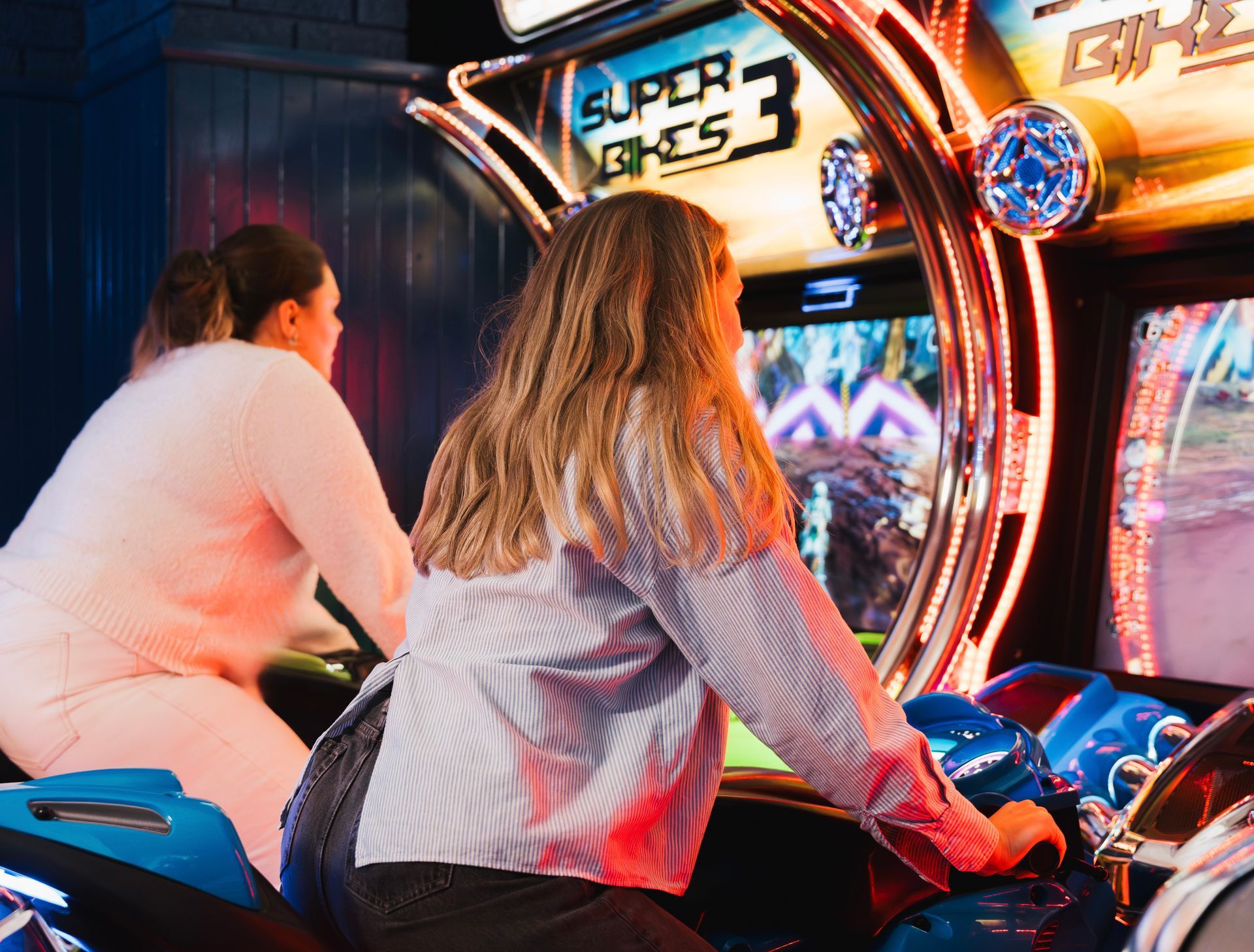 Two People Playing a Super Bikes 3 Arcade Racing Game on Bright Motorcycle Seats — Orange Tenpin Bowl in Orange, NSW