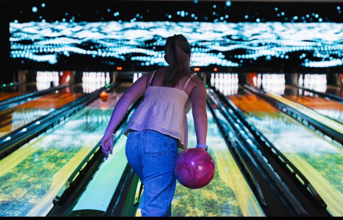 Bowler Holding a Purple Ball on a Brightly Lit Bowling Lane, Approaching the Pin — Orange Tenpin Bowl in Orange, NSW