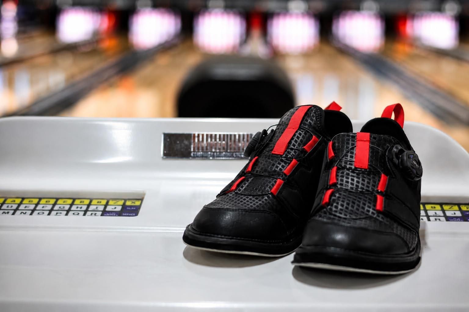 Black Bowling Shoes With Red Accents on a Lane Return at a Bowling Alley — Orange Tenpin Bowl in Orange, NSW