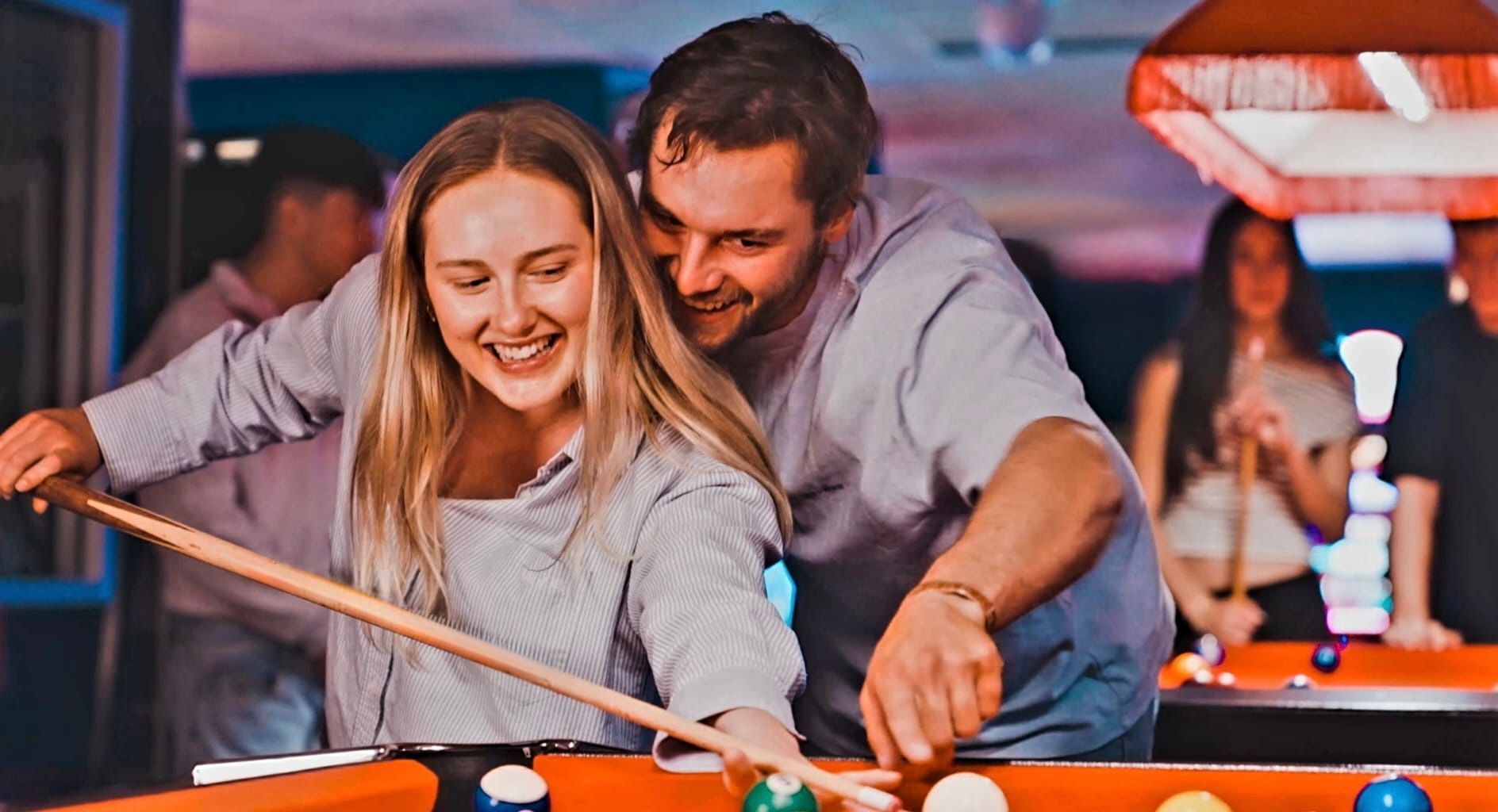 Smiling Couple Playing Pool Together in a Neon-lit Bar — Orange Tenpin Bowl in Orange, NSW