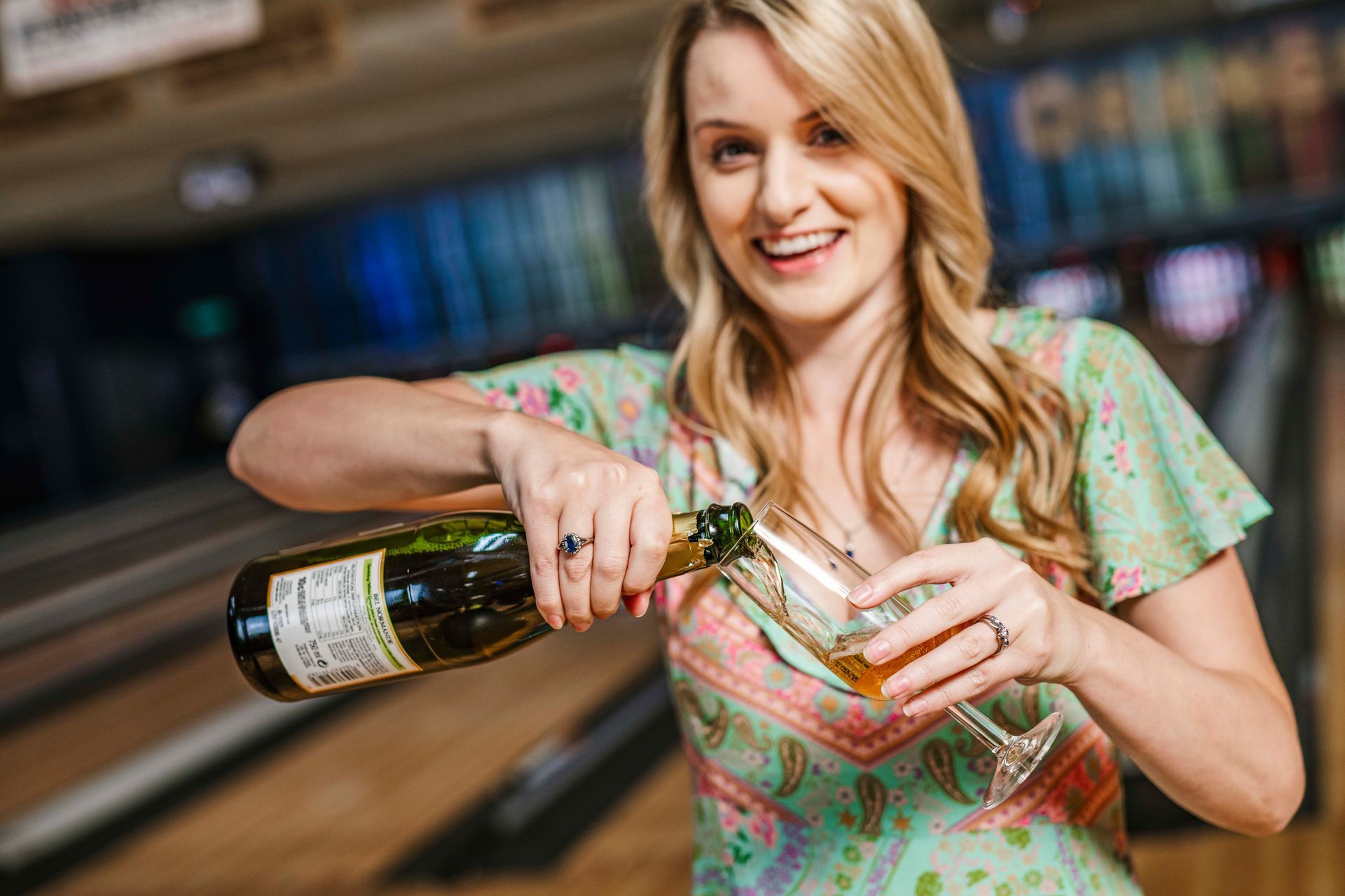 Woman Pouring Wine Into a Glass in a Store Aisle, Smiling — Orange Tenpin Bowl in Orange, NSW