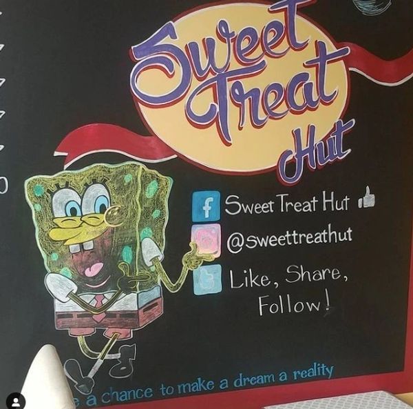 A chalkboard with spongebob on it that says sweet treat hut