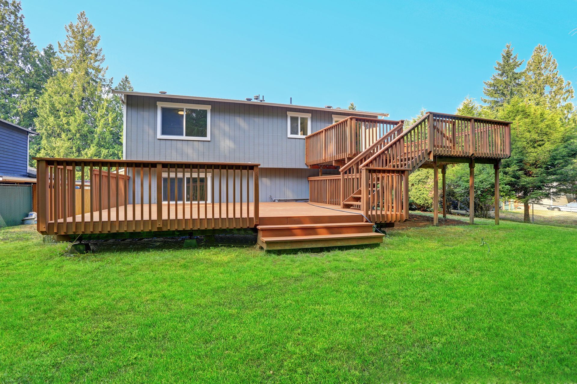Backyard view of a house with upper and lower decks.