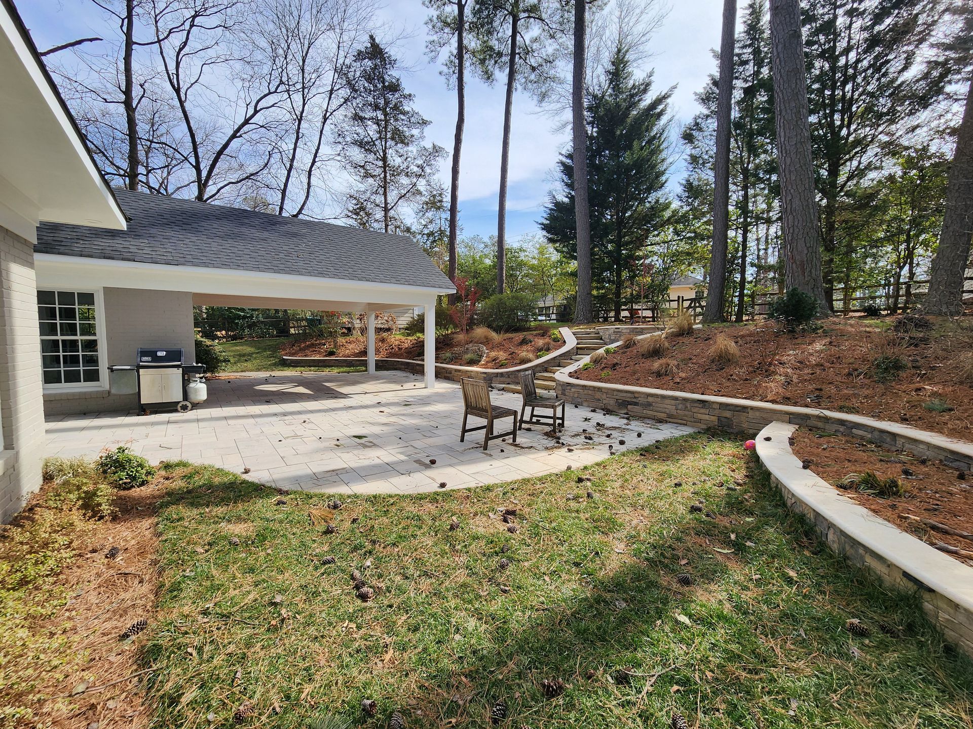 A person is standing on a deck next to a house.