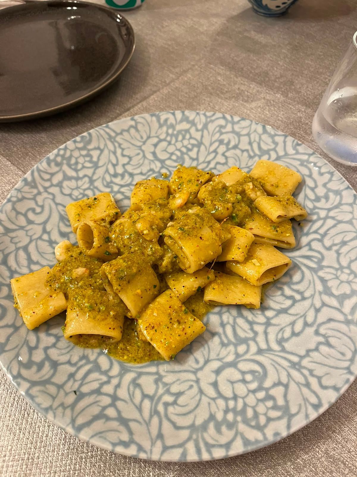 Piatto di pasta al pesto su un piatto decorato su un tavolo
