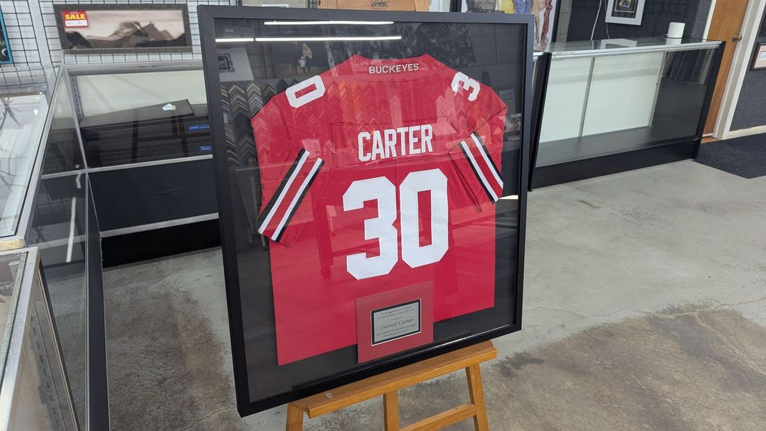 Framed red Carter #30 jersey displayed in a store window