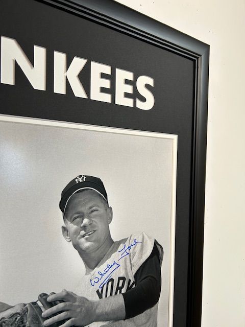 Framed black-and-white Yankees photo with a player wearing a cap and glove, signed in blue ink