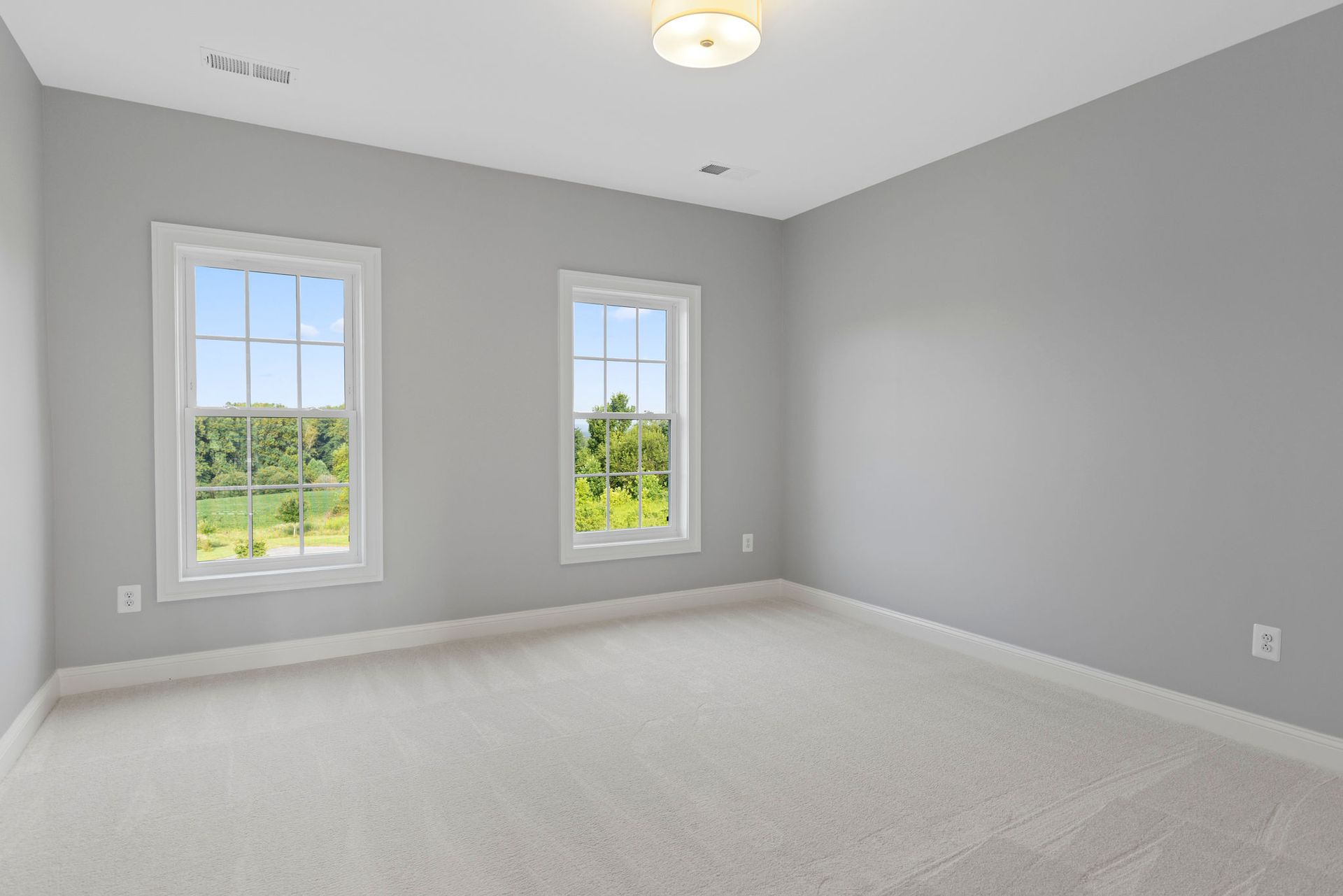 Guest bedroom remodeling project: installing new carpet, large windows, and modern trim work.