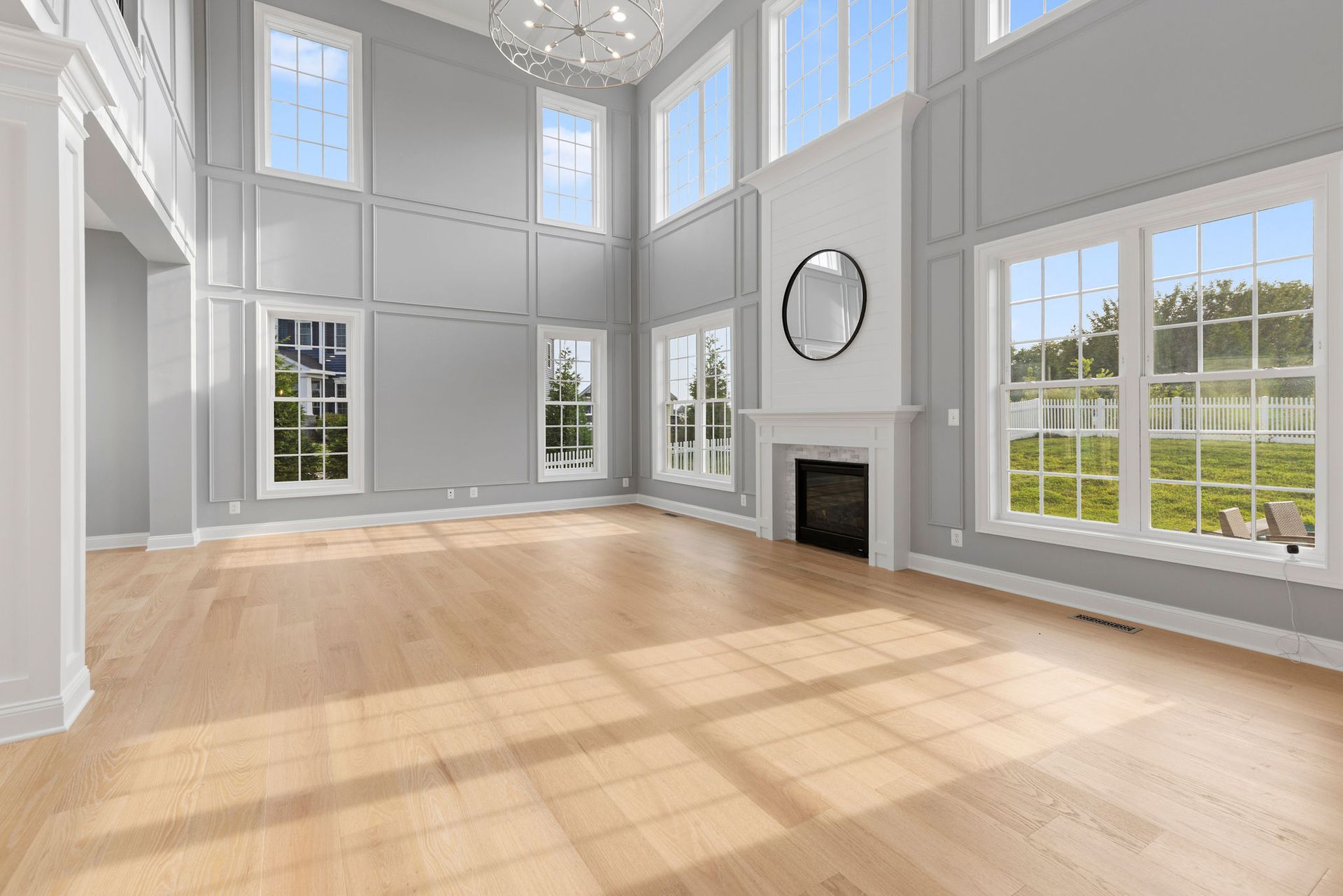 Whole home renovation and living room remodeling with two-story custom wall paneling and fireplace design services.