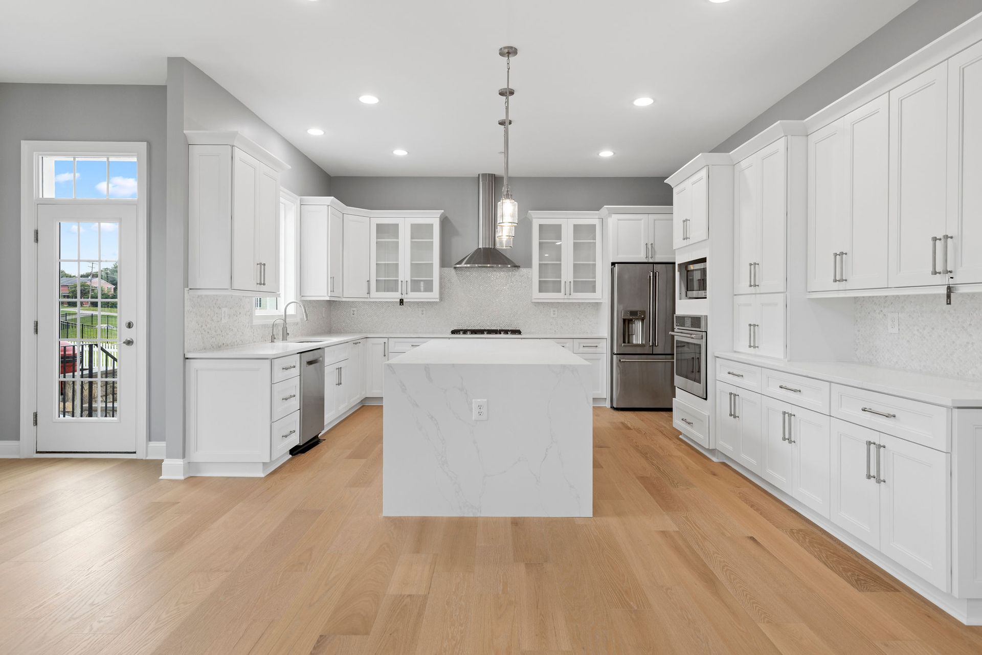Kitchen remodeling contractor installing quartz waterfall island and white Shaker cabinets in Reisterstown, MD.