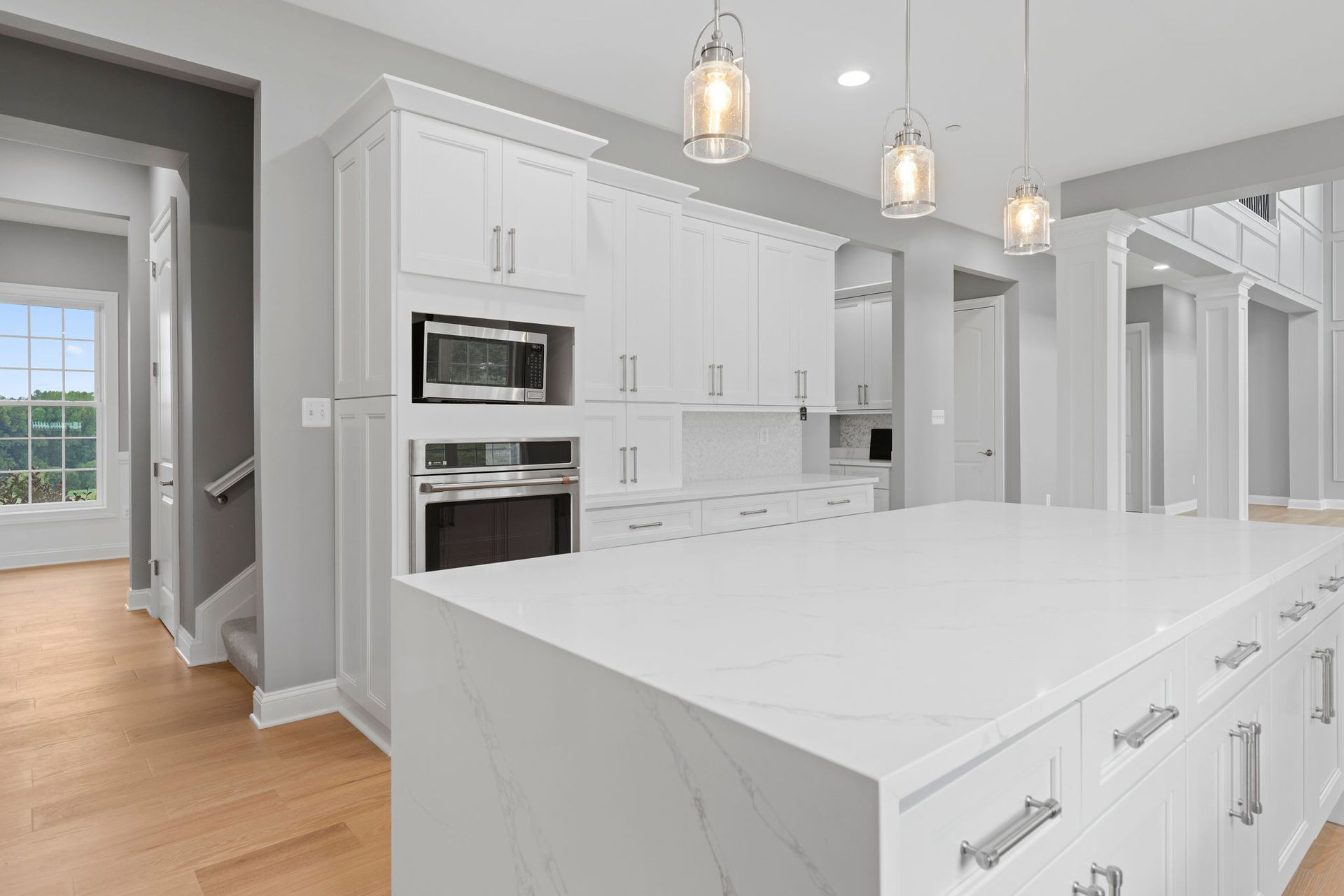 Custom kitchen island design featuring built-in oven and luxury pendant lighting. Residential contractor Reisterstown.
