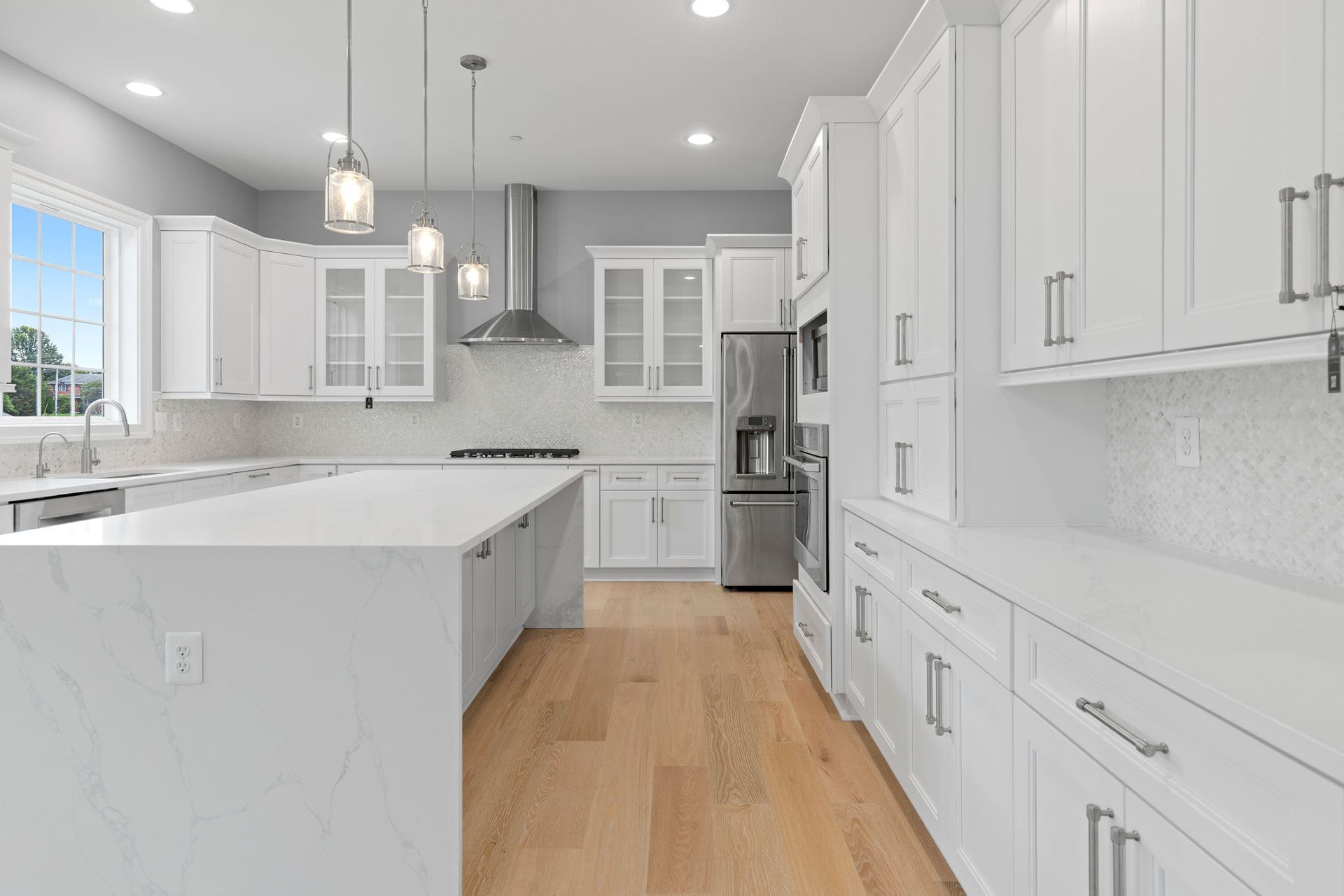 Custom kitchen cabinets and storage solutions: full wall of built-in shaker cabinetry and appliance integration.