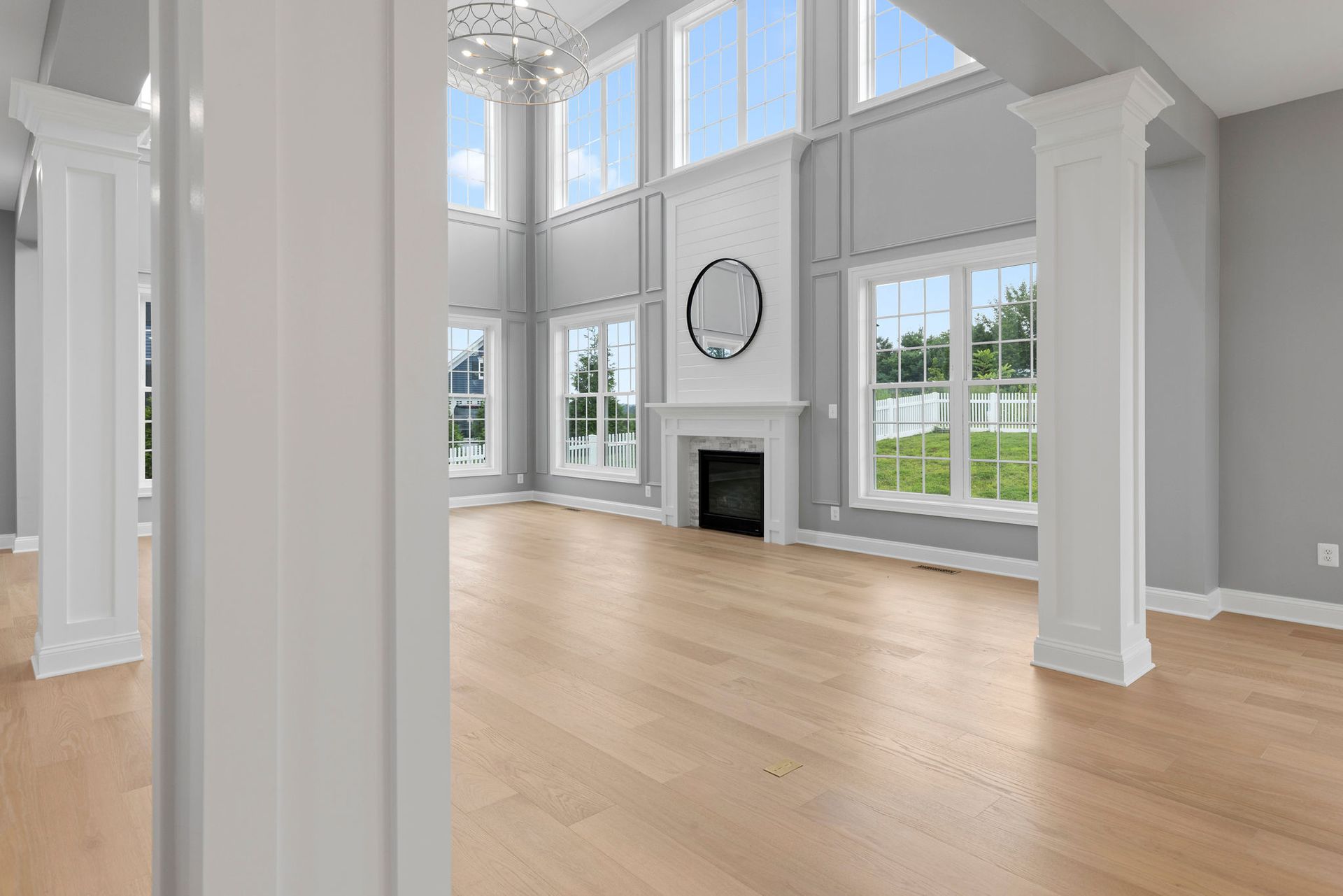 Two-story living room transformation: custom accent walls, structural pillars, and luxury fireplace design.