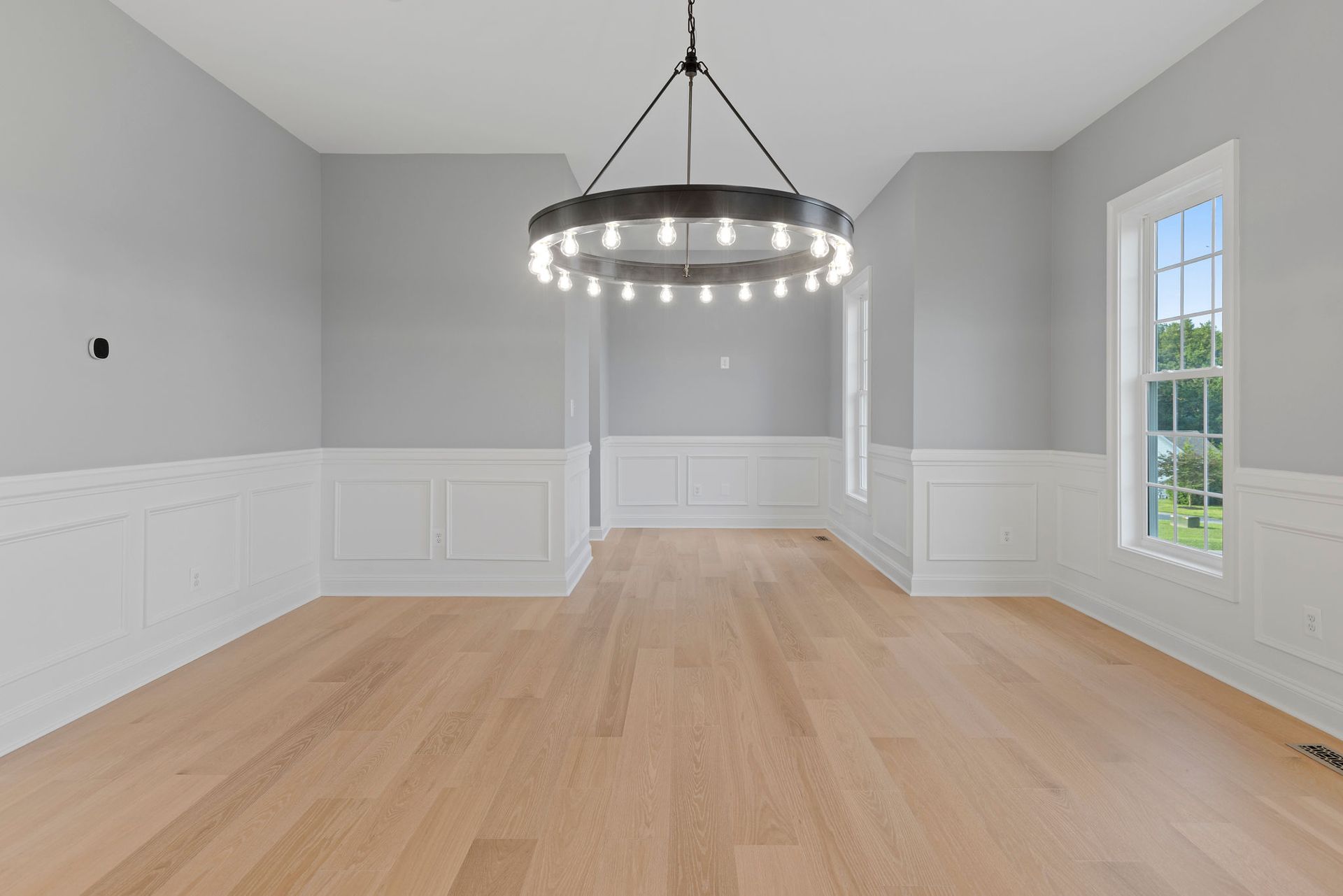 Formal dining room remodeling: luxury custom trim and wainscoting installation with a modern chandelier.