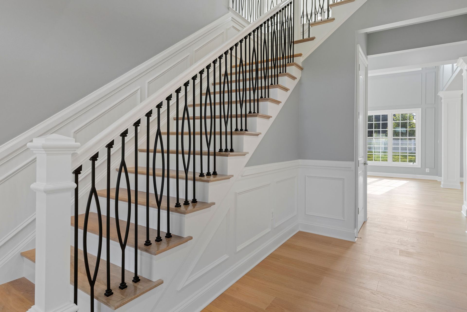 Staircase design ideas: black iron balusters, hardwood stairs, and custom accent trim by A1 Renovations.
