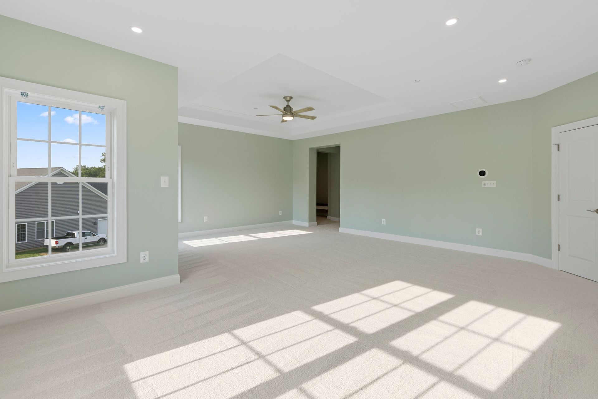 Primary bedroom suite renovation: installing ceiling fan, custom trim, and new luxury carpeting.