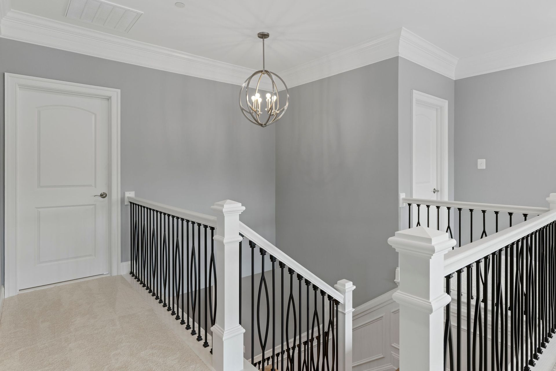 Second floor landing remodel: luxury iron baluster railing, newel posts, and custom crown molding installation.