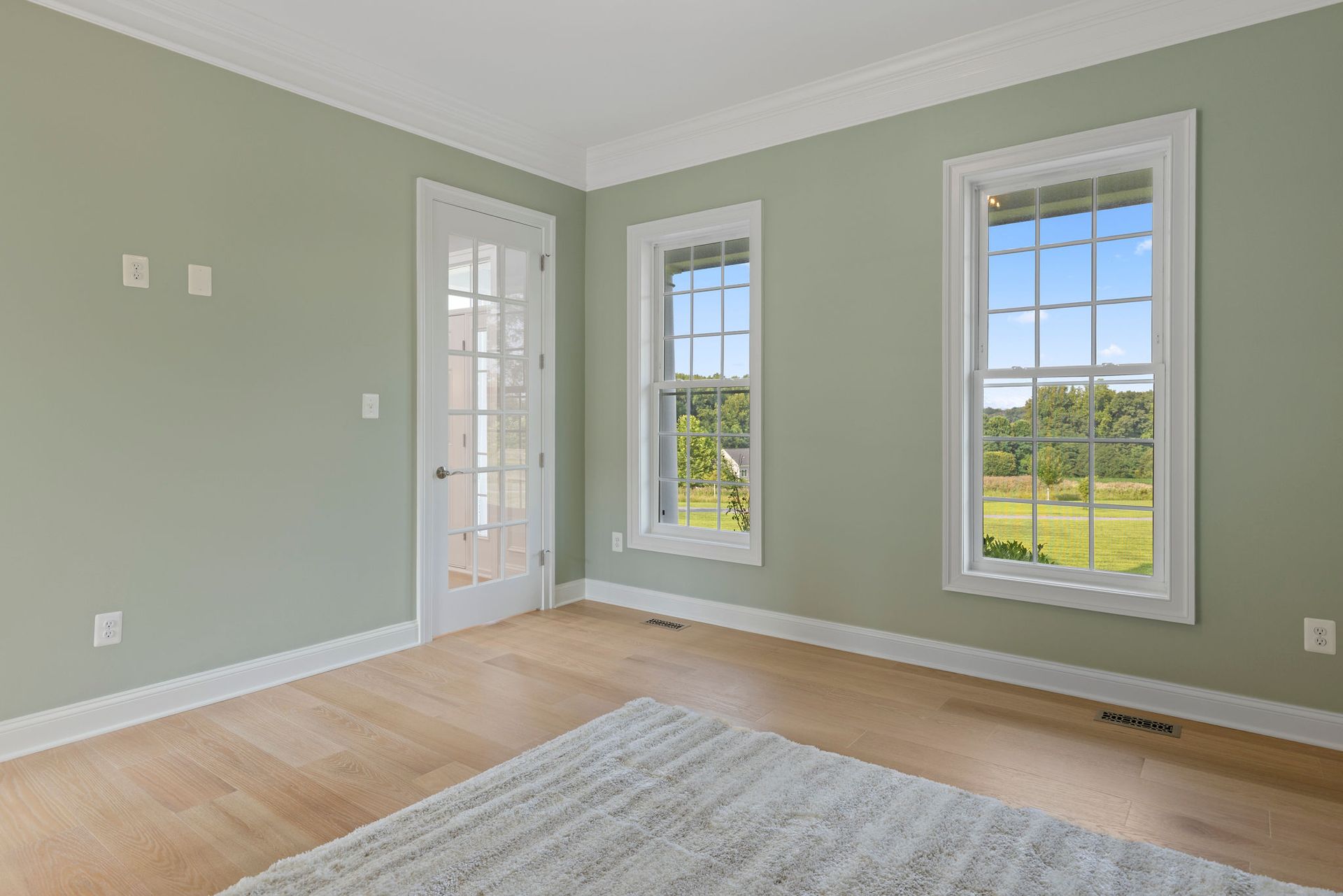 Home office renovation: installing hardwood flooring, glass French door, and custom baseboard trim.