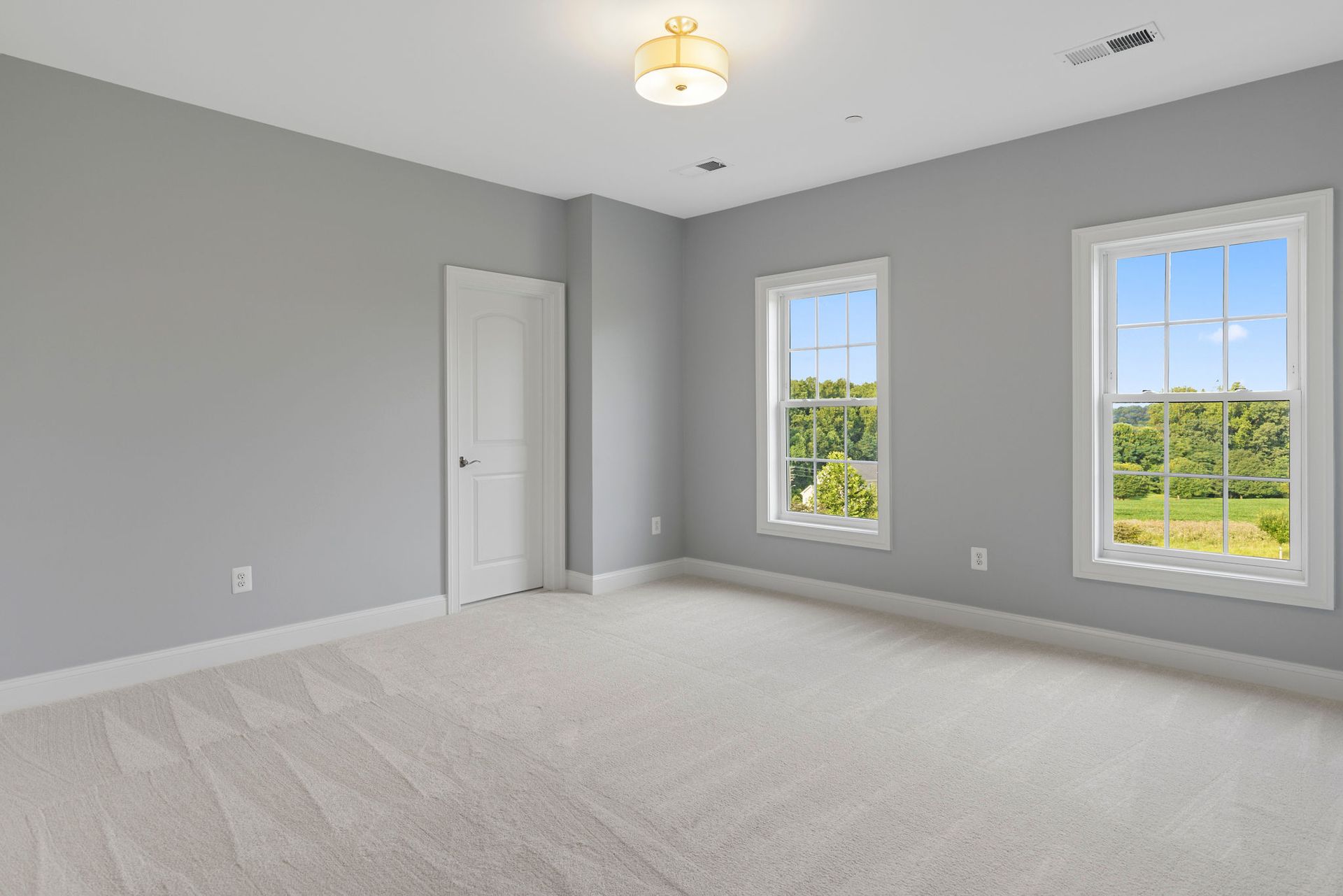 Second bedroom renovation: installing new carpet, modern lighting, and trim in a high-quality home remodel.