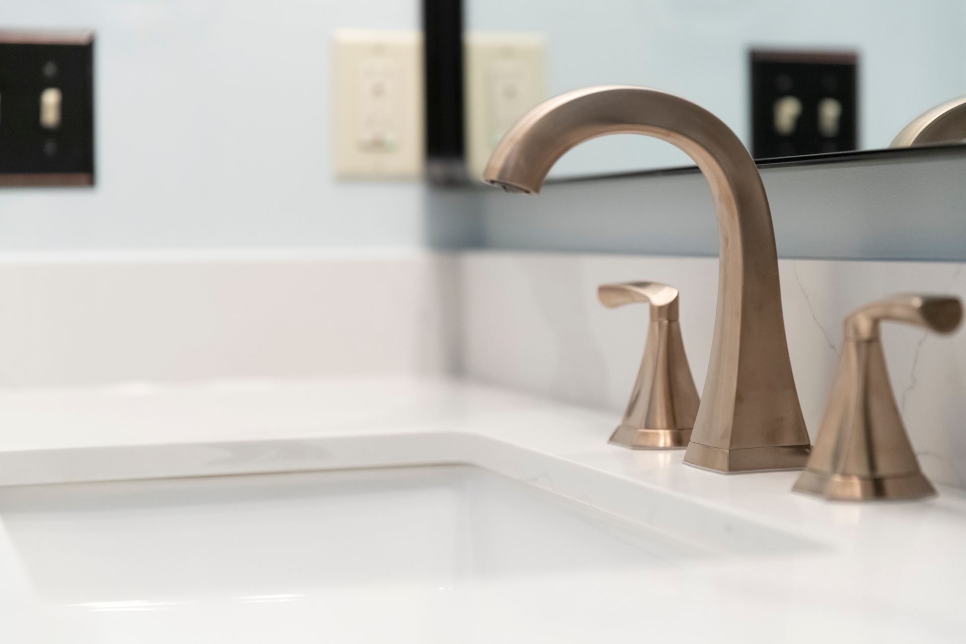 Newly relocated plumbing and electrical work to accommodate a modern centered vanity and illuminated wall mirror.