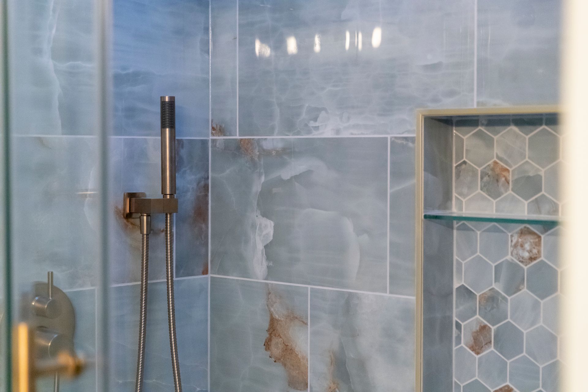 Expertly installed large-format wall tiles in a neutral palette, creating a spa-like atmosphere in this Bel Air home.