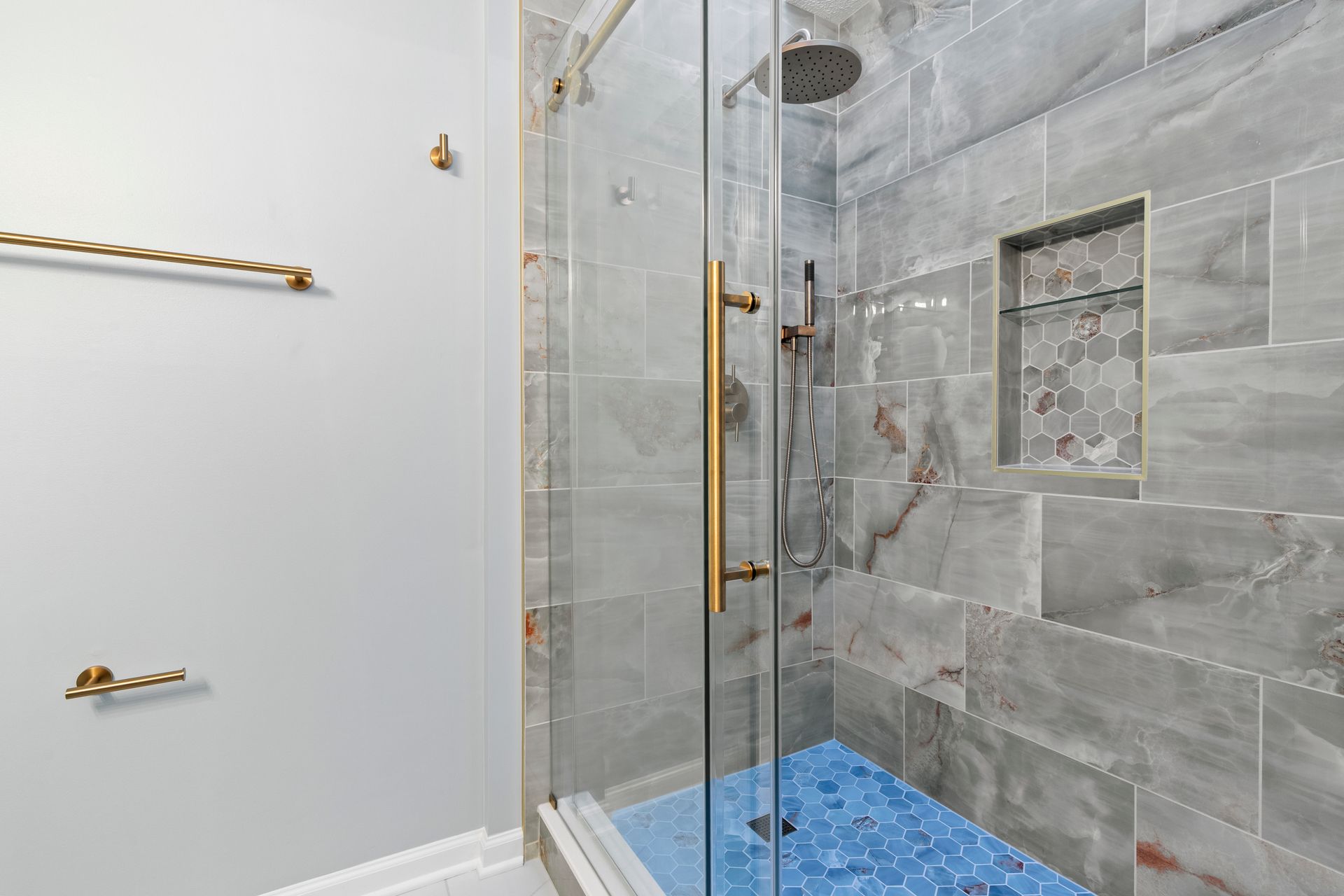 Modern bathroom design featuring a bright, open walk-in shower with high-end fixtures and a built-in storage niche.