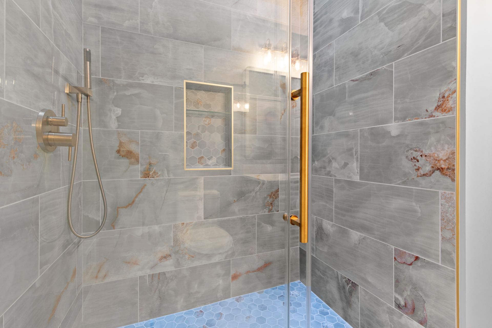 Modern bathroom design featuring a bright, open walk-in shower with high-end fixtures and a built-in storage niche.