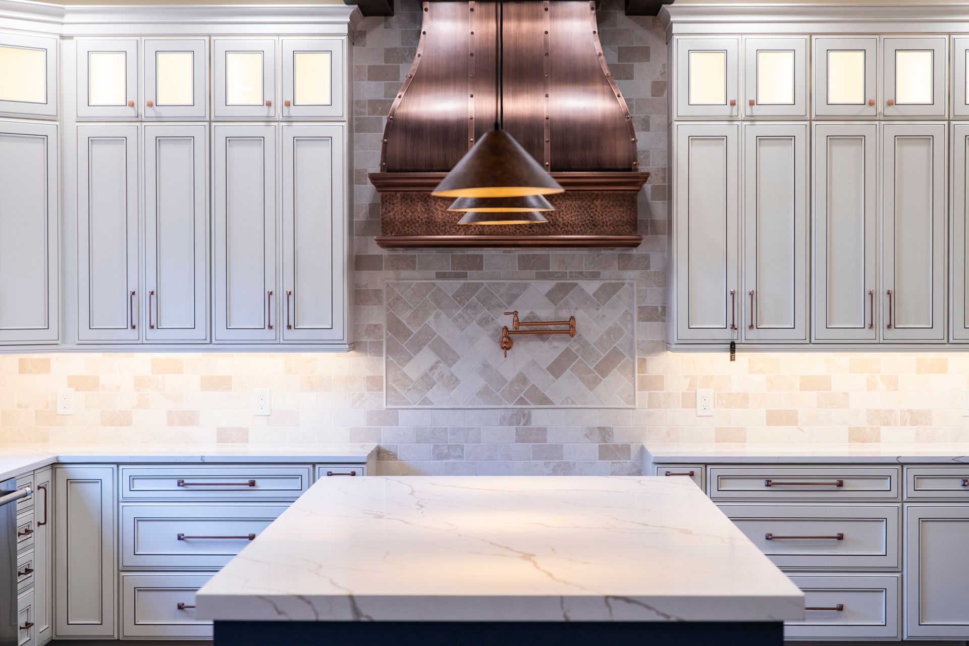 A close-up of the elegant golden pendant lights hanging over the kitchen island.