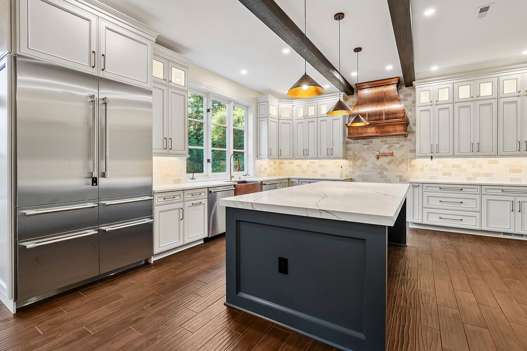 A modern kitchen showing stainless steel appliances and a stylish patterned tile backsplash.