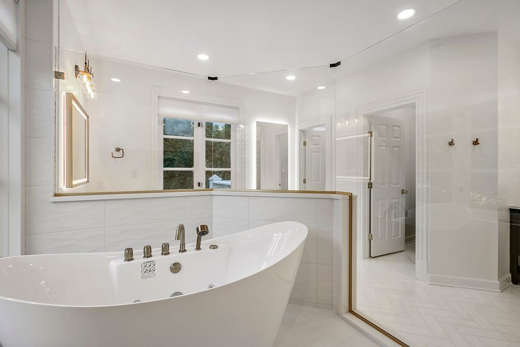 A close-up of the new modern jacuzzi tub inside the custom-built shower area, showing the sleek design and new gold faucets in Cockeysville, MD.