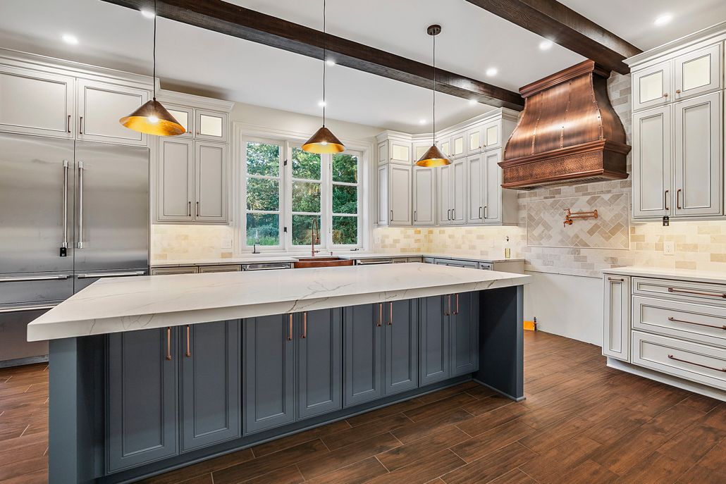 A close-up of a rustic copper farmhouse sink with a matching faucet, set into a clean white countertop.