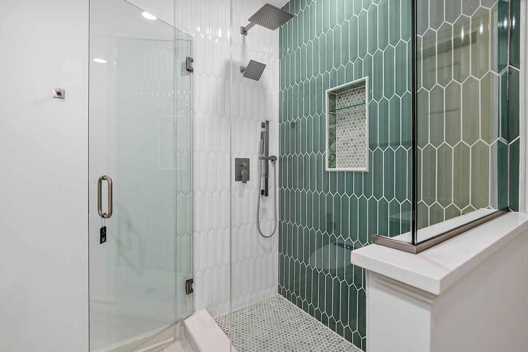 Luxury walk-in shower construction with seamless glass, dual rain heads, and specialized, high-impact vertical picket tile for a custom look.