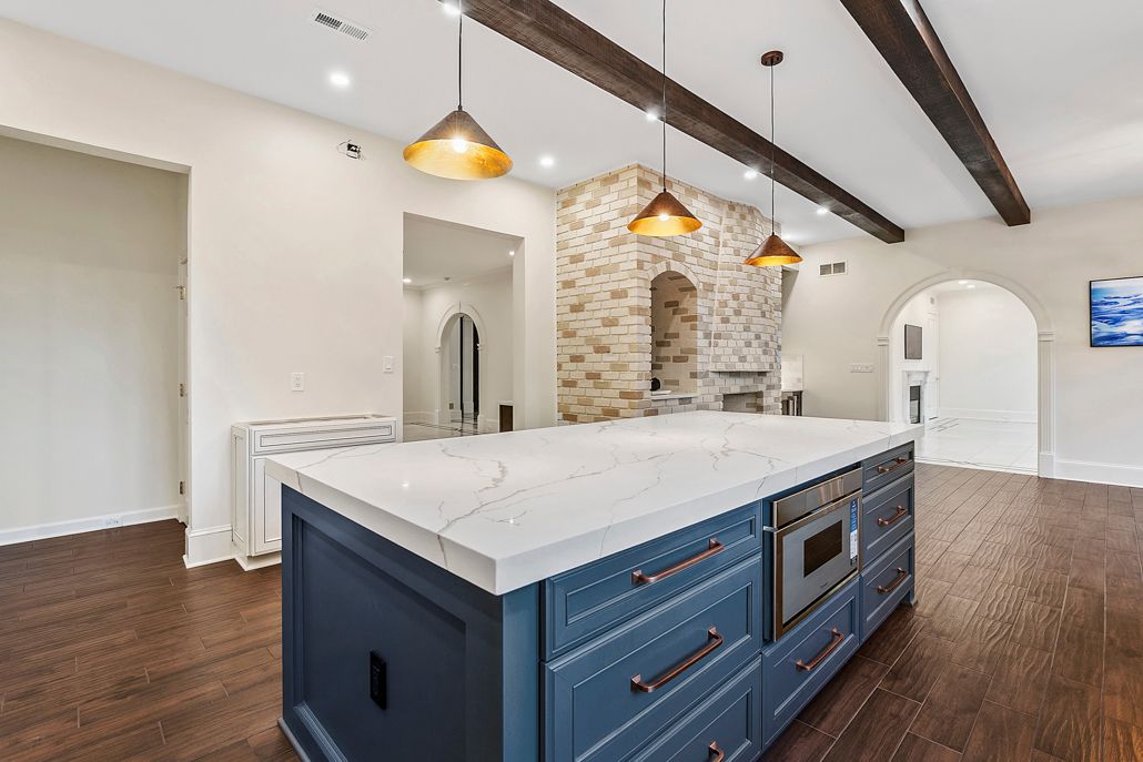 A professional shot of the home's new white granite countertops and a sleek, stainless steel stove.