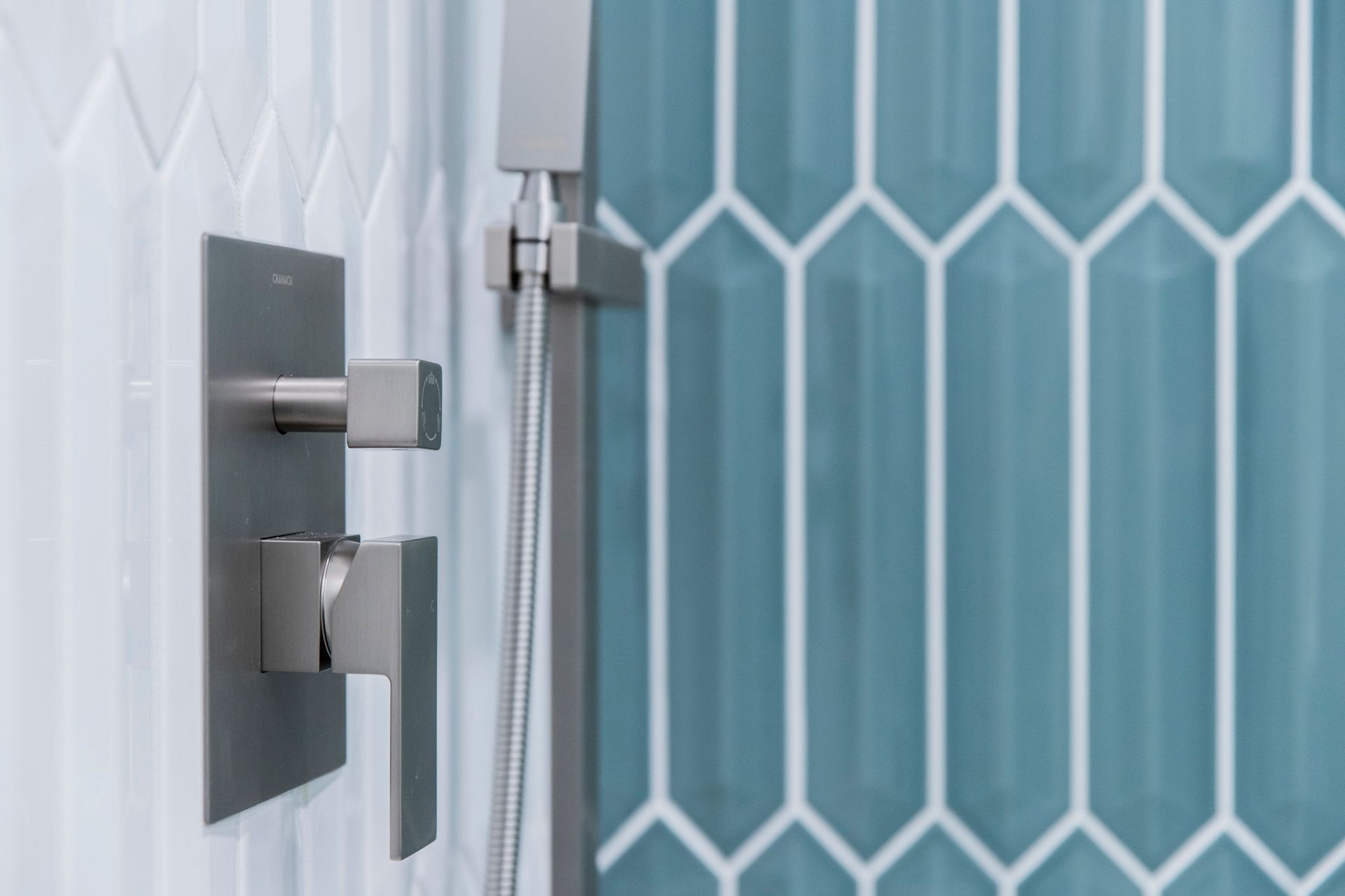 Modernizing your bathroom with sleek, square, matte gray shower controls and quality valves installed perfectly against textured tile.