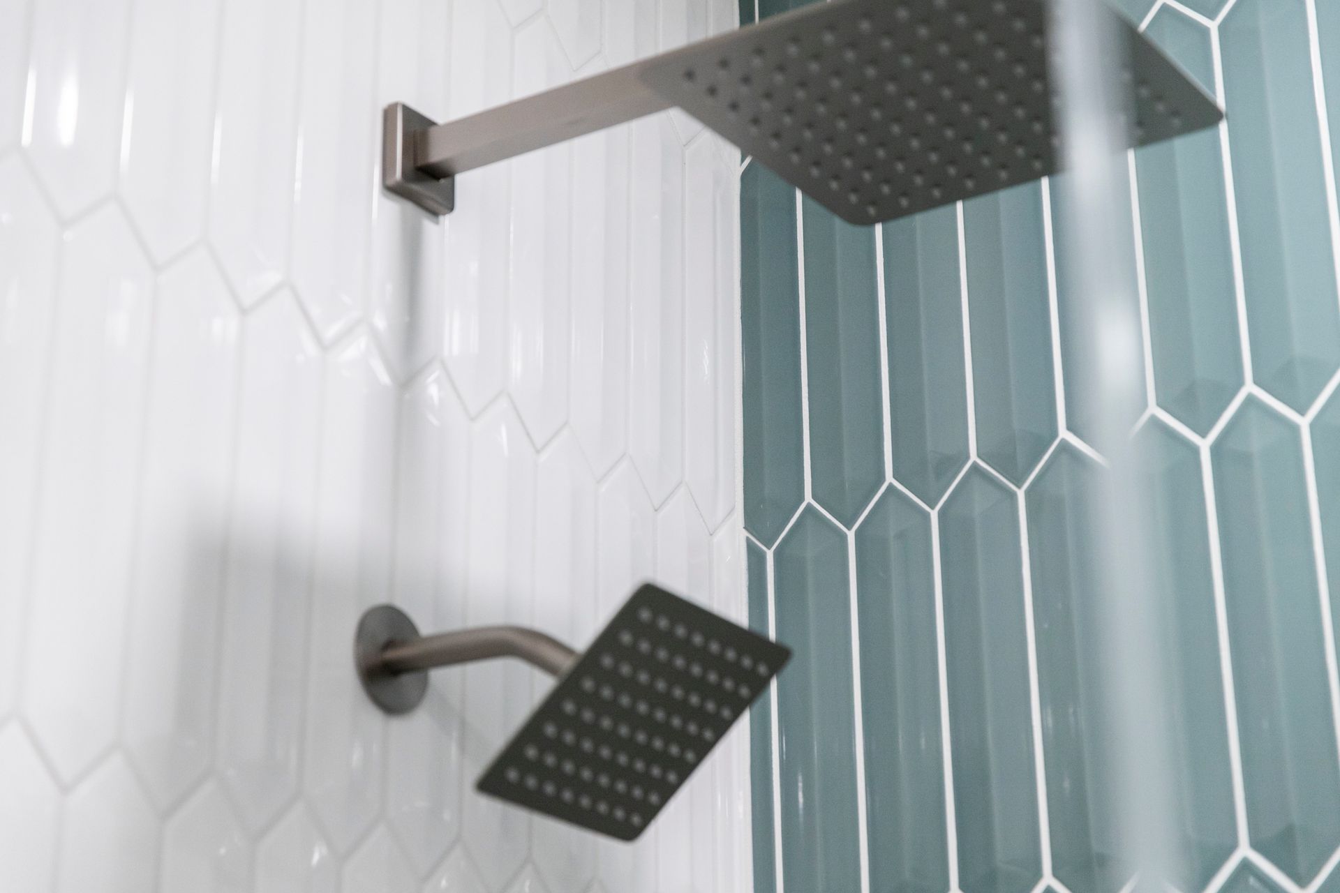 Professional shower system installation including adjustable handheld sprayers and contemporary controls for maximized comfort and usability.