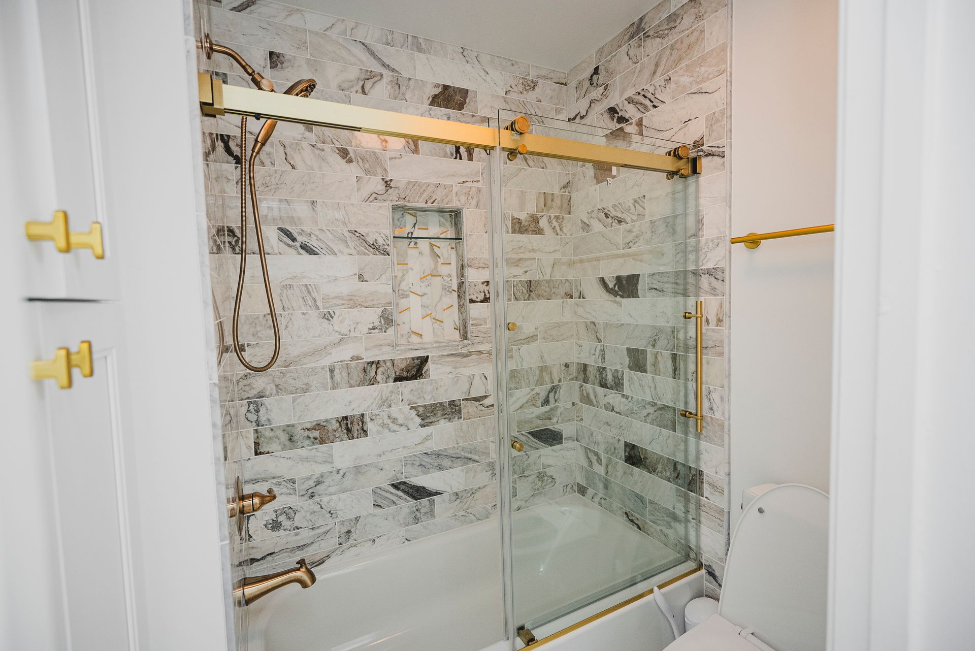 Luxury bathroom renovation with high-end tile work and updated lighting fixtures.