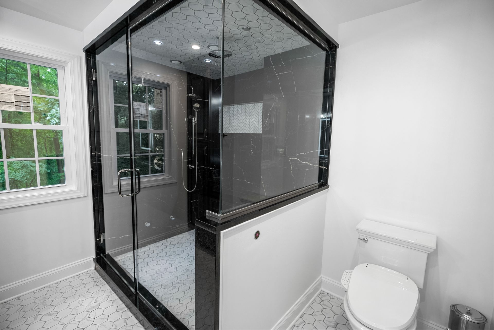 Custom white herringbone tile niche accent inside a black marble shower