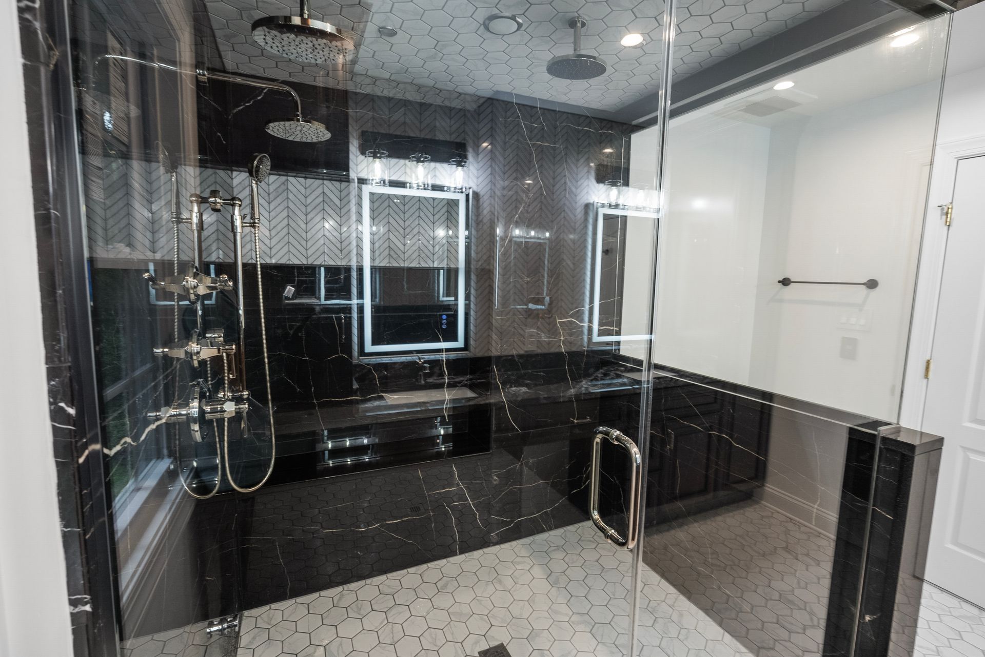 Luxury steam shower interior showing dual rain showerheads and built-in stone bench