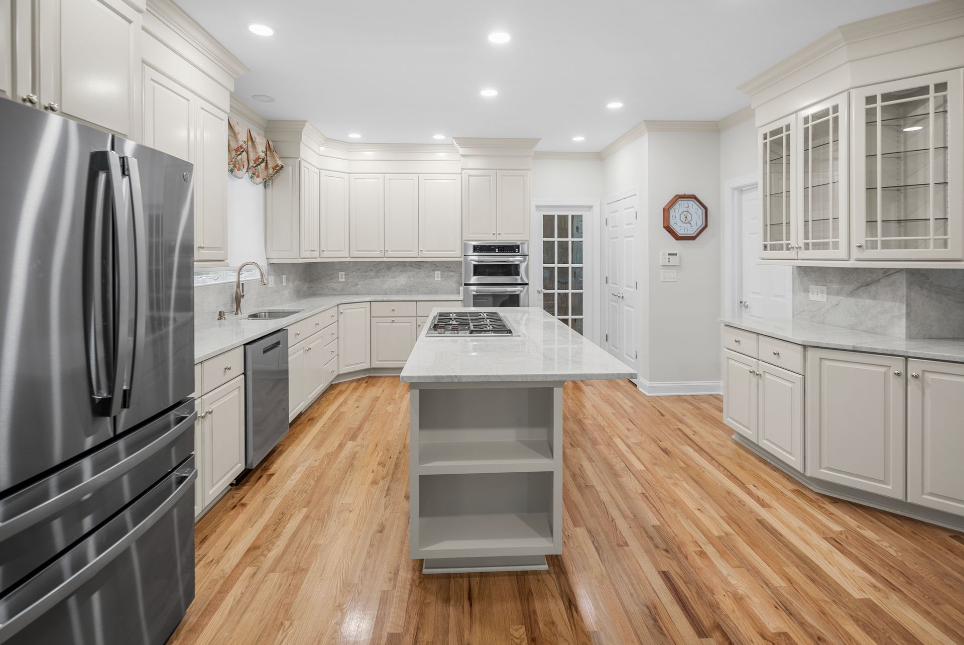 Overall view of an executive kitchen renovation with custom crown molding and light stone surfaces