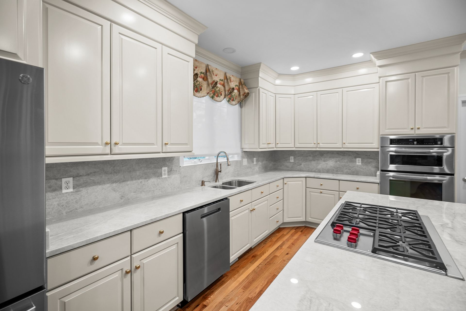 Dedicated corner wet bar with glass-front display uppers and continuous stone slab backsplash