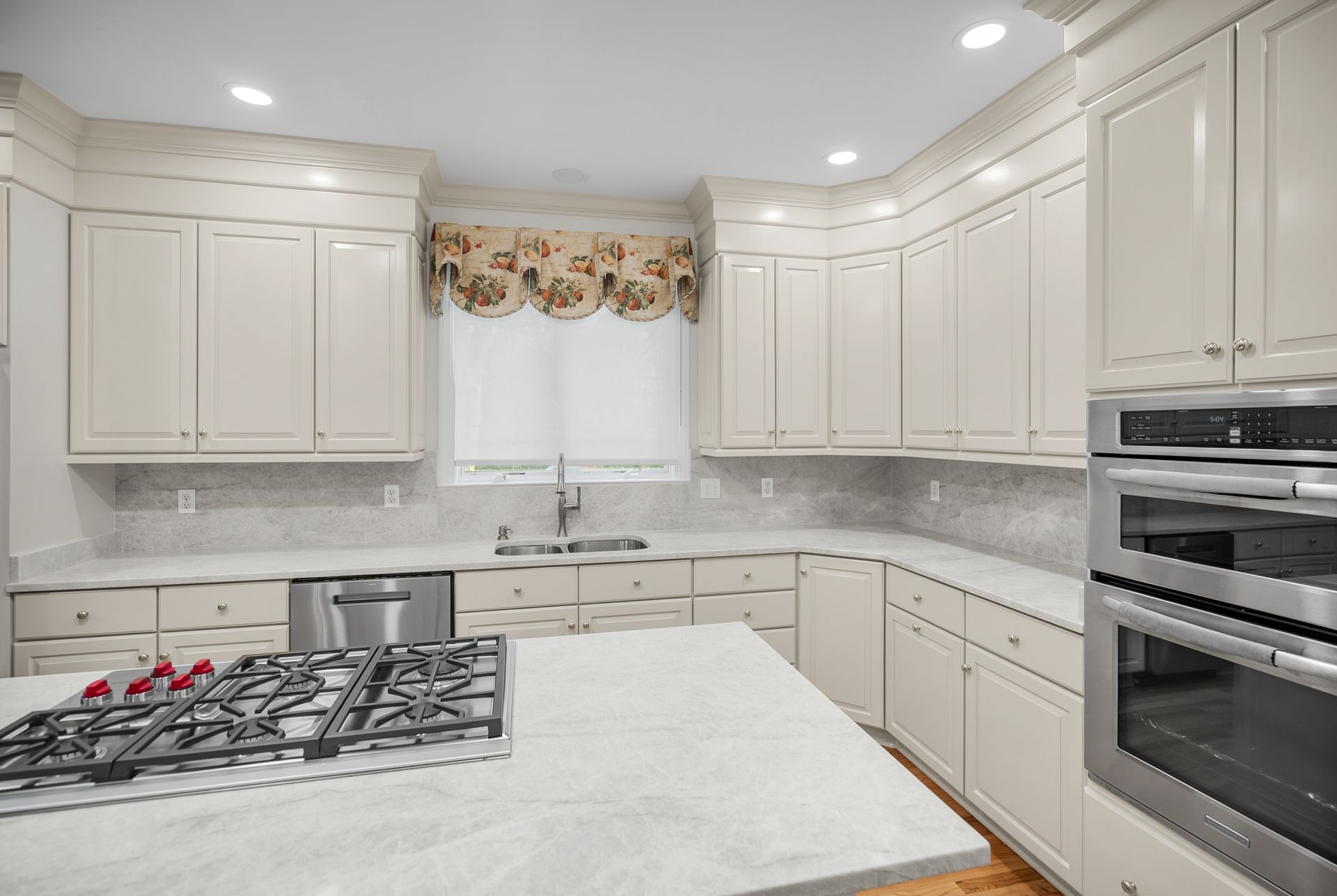 High-end primary kitchen overhaul showing refinished wood cabinets and natural hardwood flooring