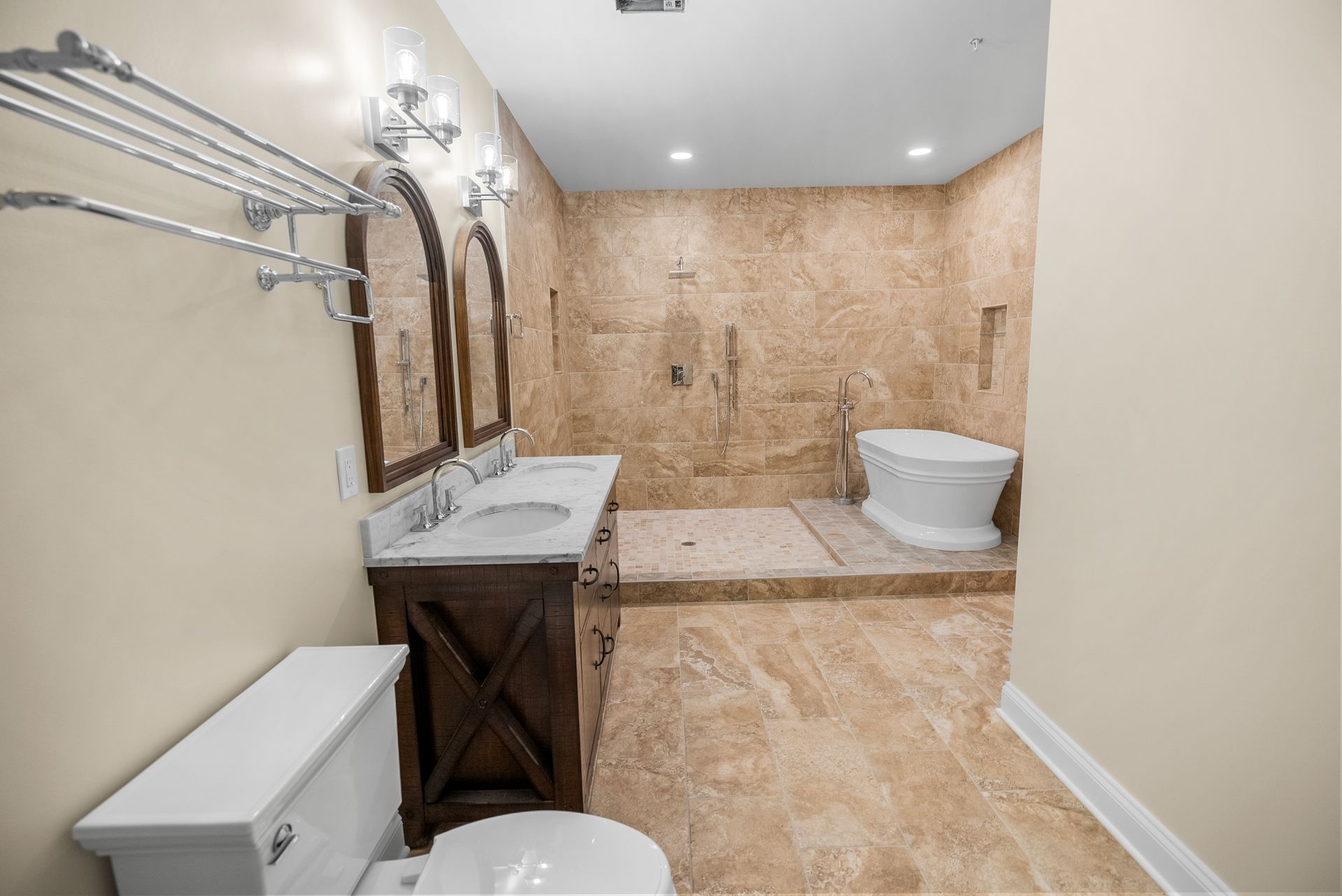 Custom basement spa bathroom featuring travertine tile surround, double vanity, and standalone soaking tub