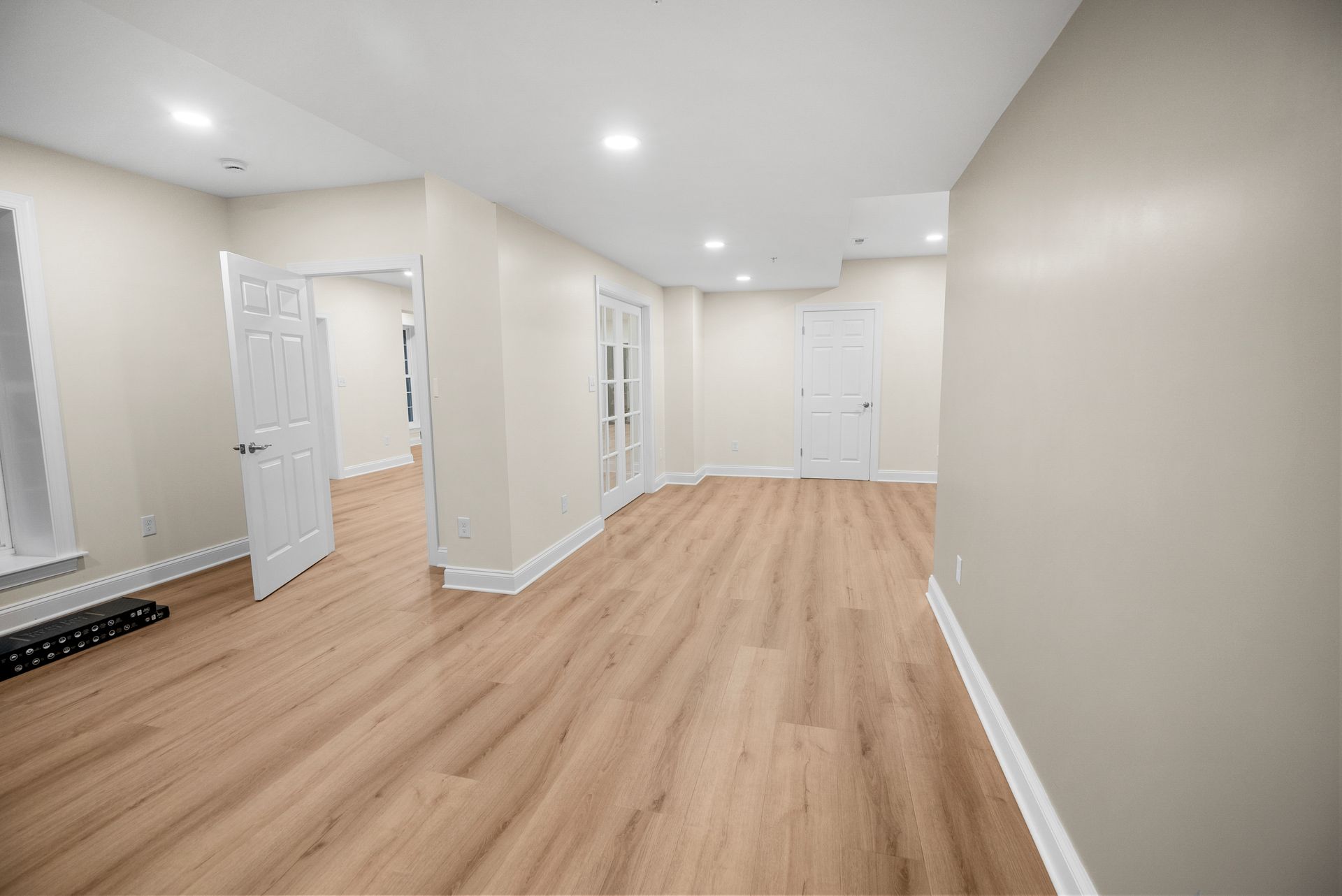 Finished basement egress window nook with custom white sill trim and surrounding recessed lights.