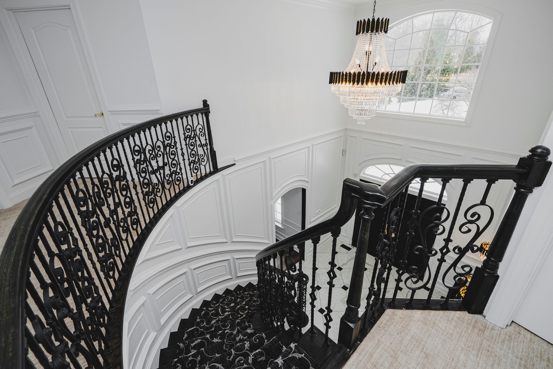 Patterned designer carpet runner installed on a refinished hardwood staircase.