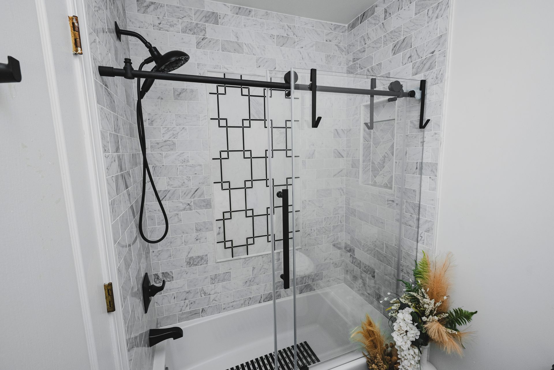 Sleek sliding glass barn-door style enclosure for a bathtub and shower combo.