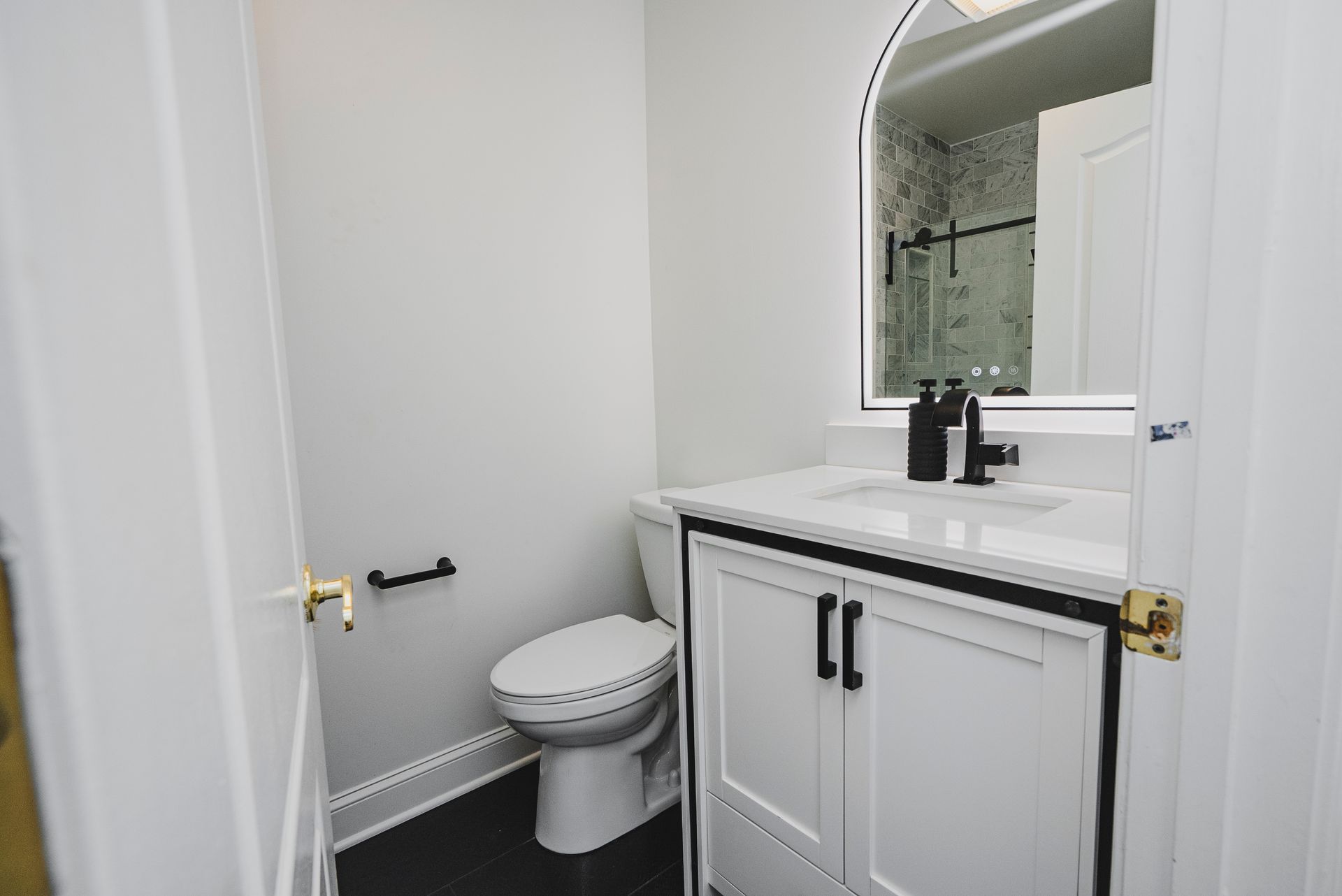 Arched LED backlit mirror installed over a new bathroom vanity.